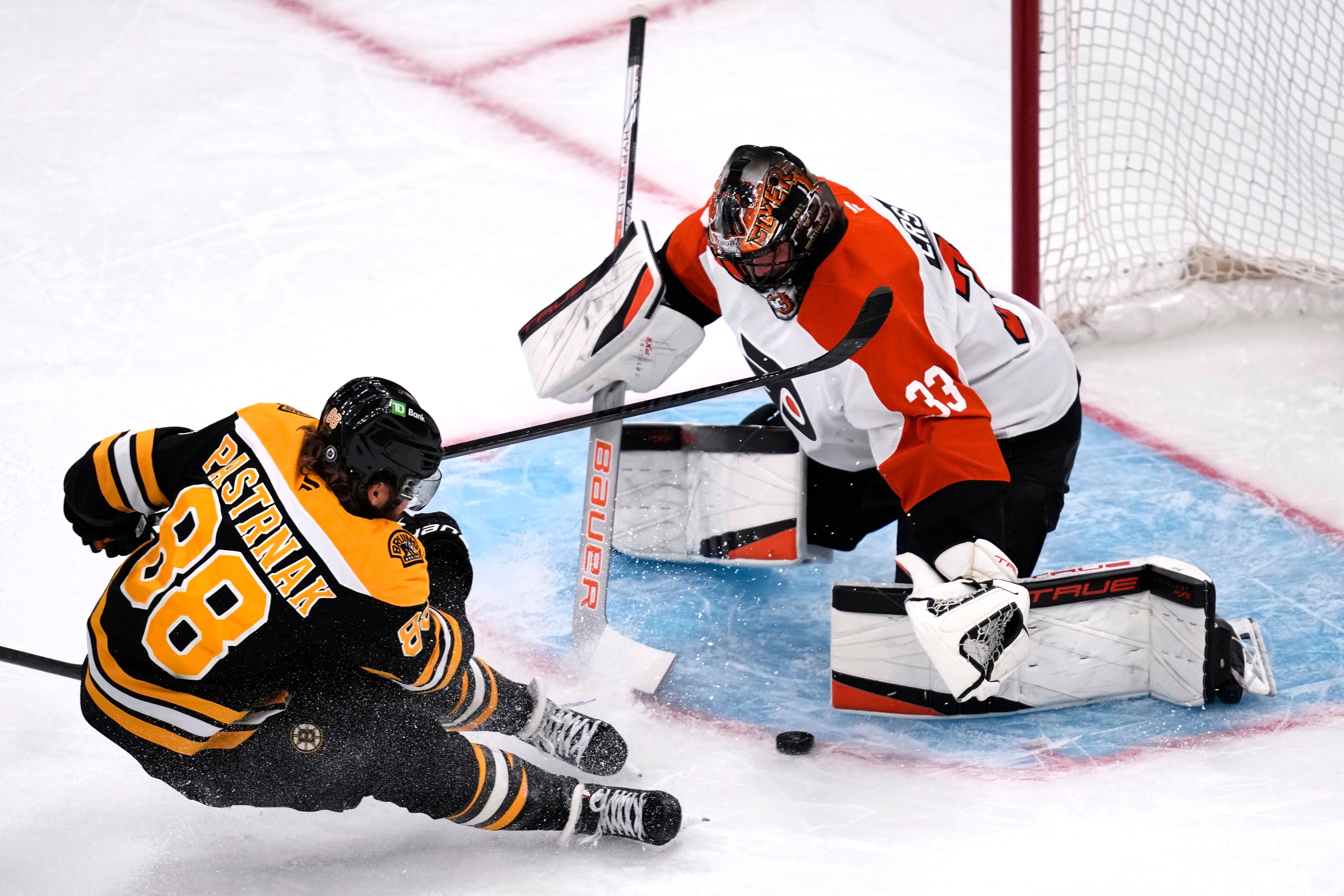 Philadelphia Flyers goaltender Samuel Ersson (33) drops to the ice to make a save on a shot by Boston Bruins right wing David Pastrnak (88) during the first period of an NHL hockey game, Tuesday, Oct. 29, 2024, in Boston. (AP Photo/Charles Krupa)