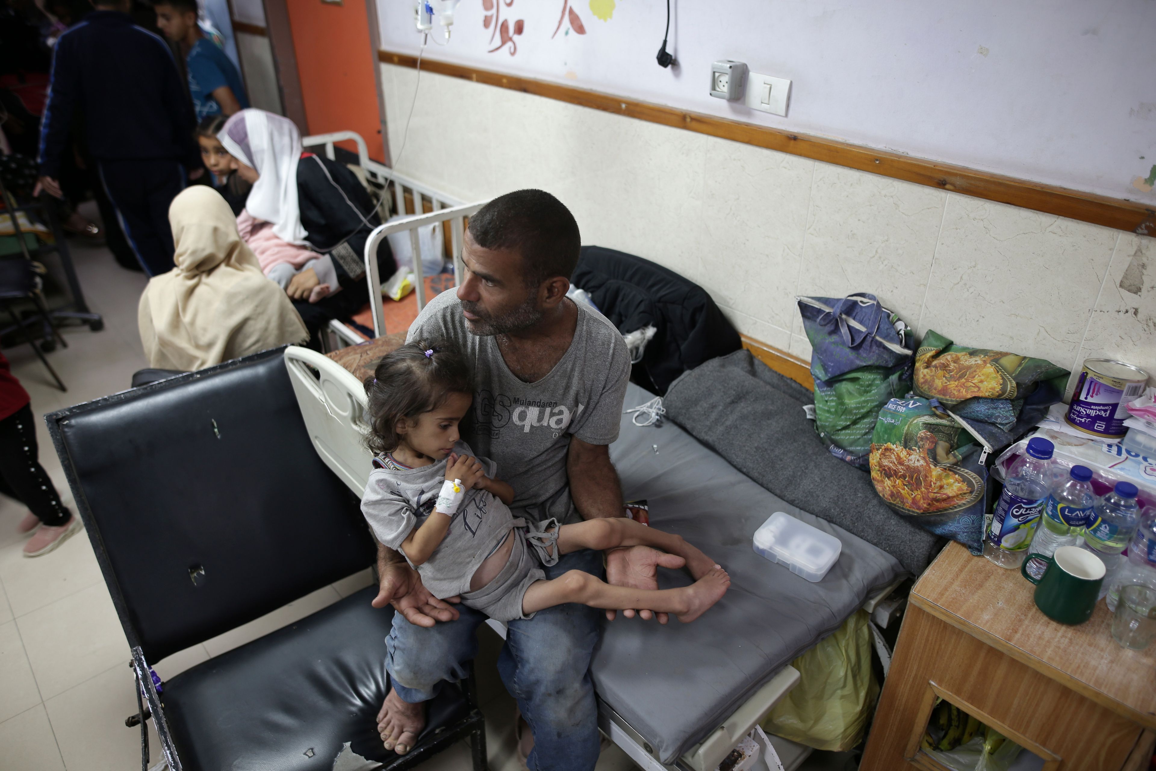 FILE - Abdulrahman Al-Rai holds his daughter Hana Al-Rai, 3, who suffers from diabetes, a weakened immune system and malnutrition at Al-Aqsa Martyrs Hospital in Deir al-Balah in the central Gaza Strip, where she is receiving treatment, on June 1, 2024. (AP Photo/Jehad Alshrafi)