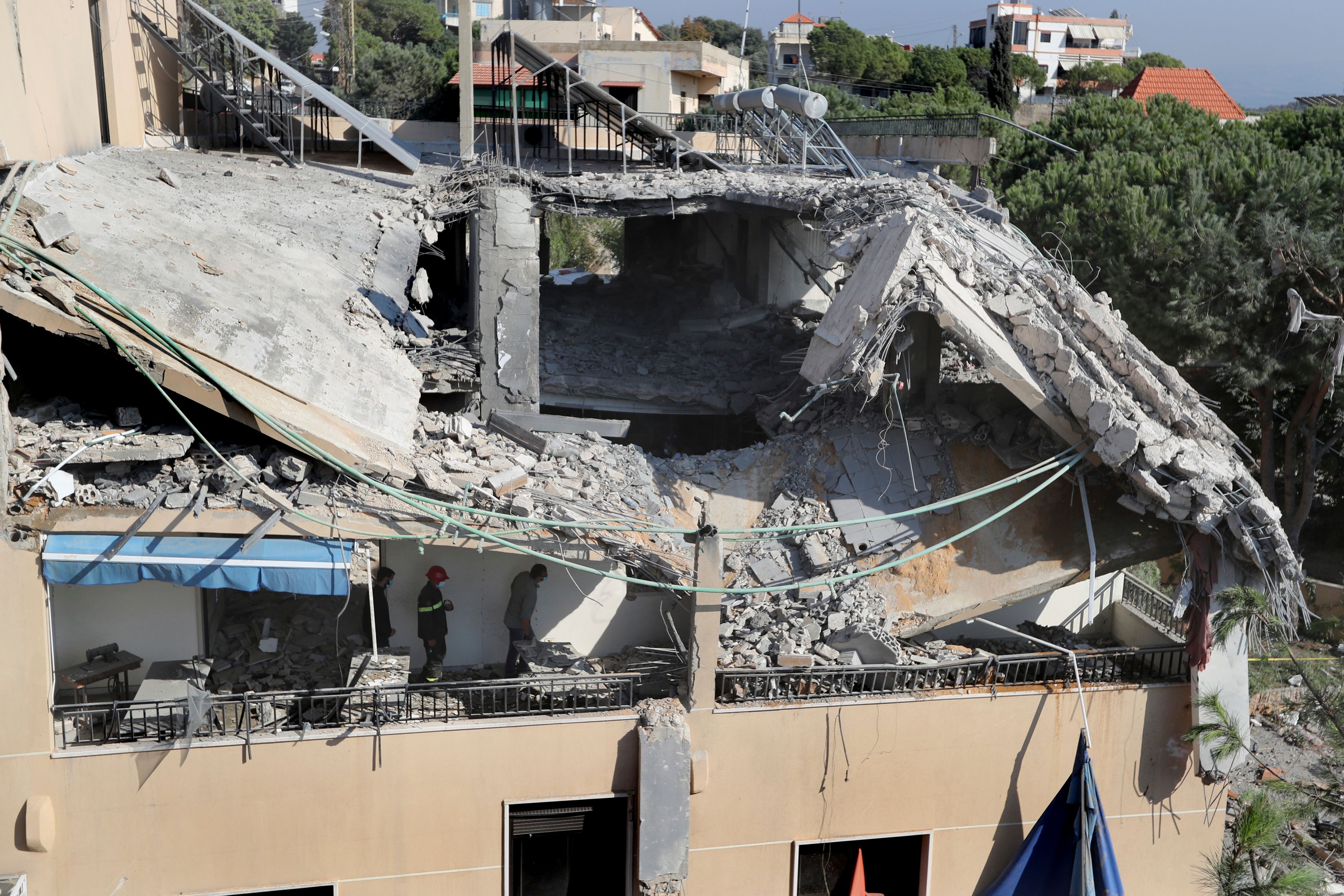 Rescue workers search for victims on a hotel-turned-shelter for displaced people hit by an Israeli airstrike, in Wardaniyeh, south Lebanon, Wednesday, Oct. 9, 2024. (AP Photo/Mohammed Zaatari)