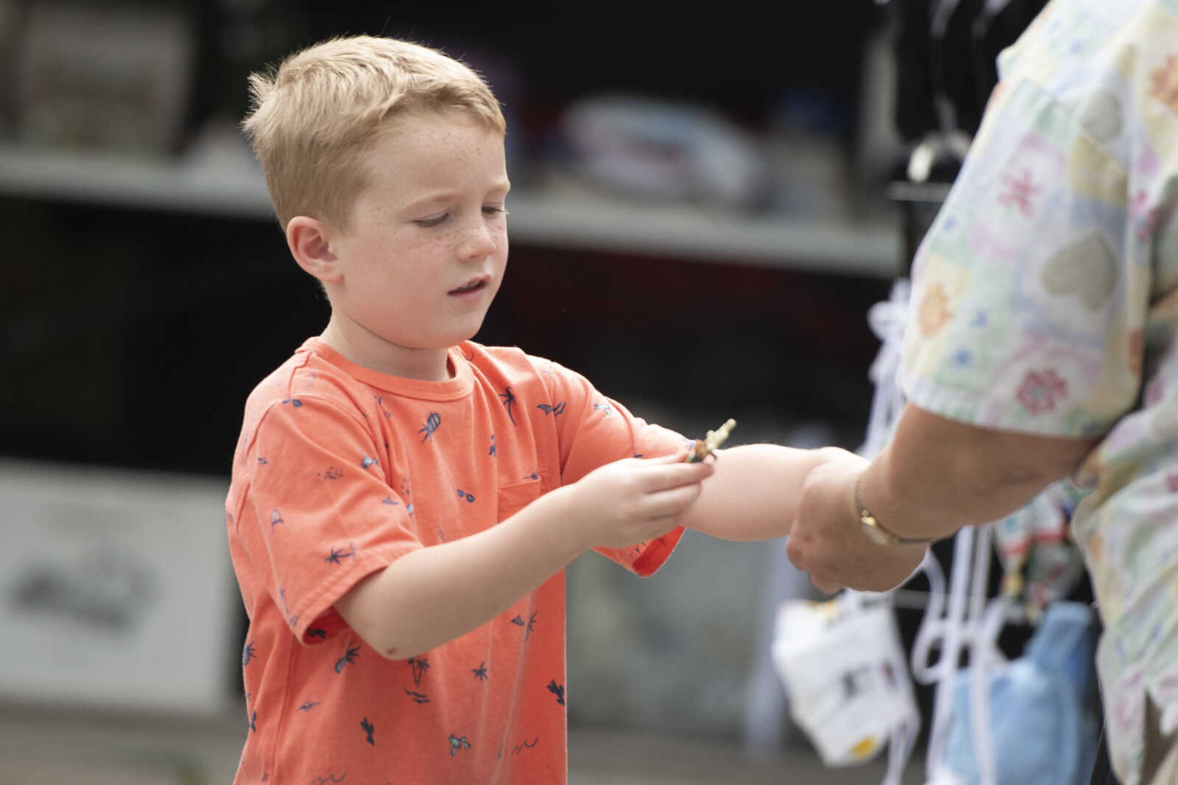 Archie Stroup, 5, of Farmington, Missouri, pays for merchandise at a sale between Jackson and Gordonville during the 100-Mile Yard Sale on Saturday, May 23, 2020, along Highway 25.&nbsp;