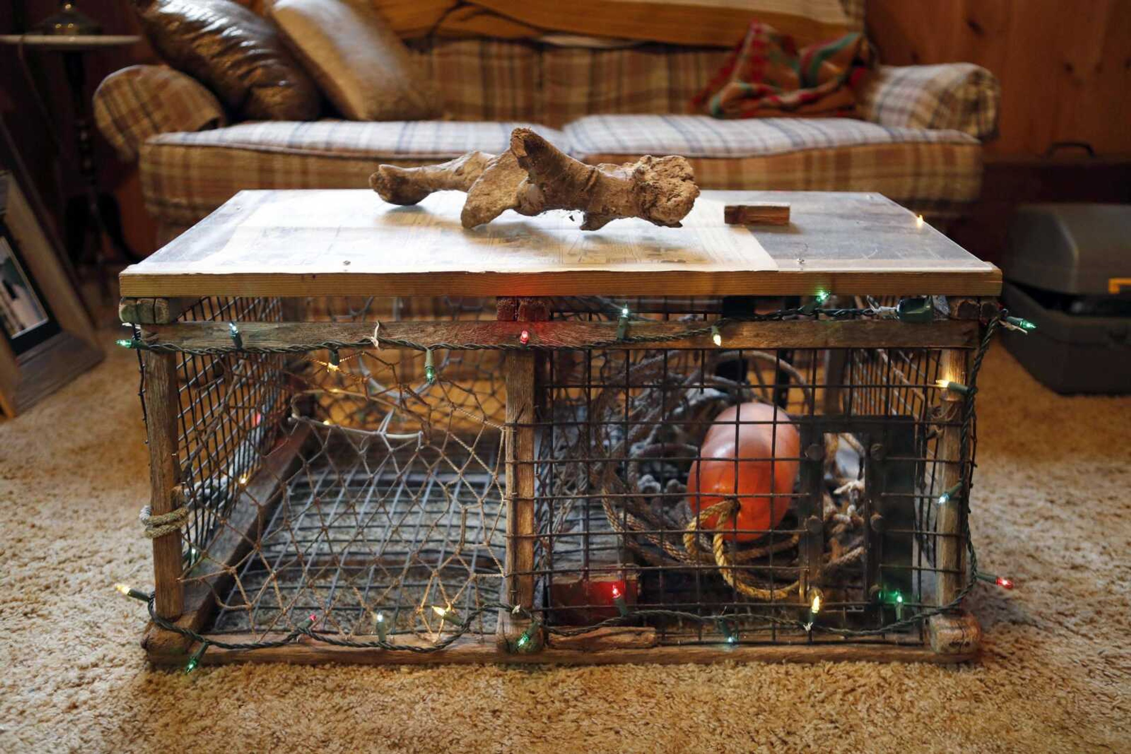 This Nov. 2 photo shows a discarded lobster trap that was converted into a coffee table by Glenn Adams at his home in Augusta, Maine.