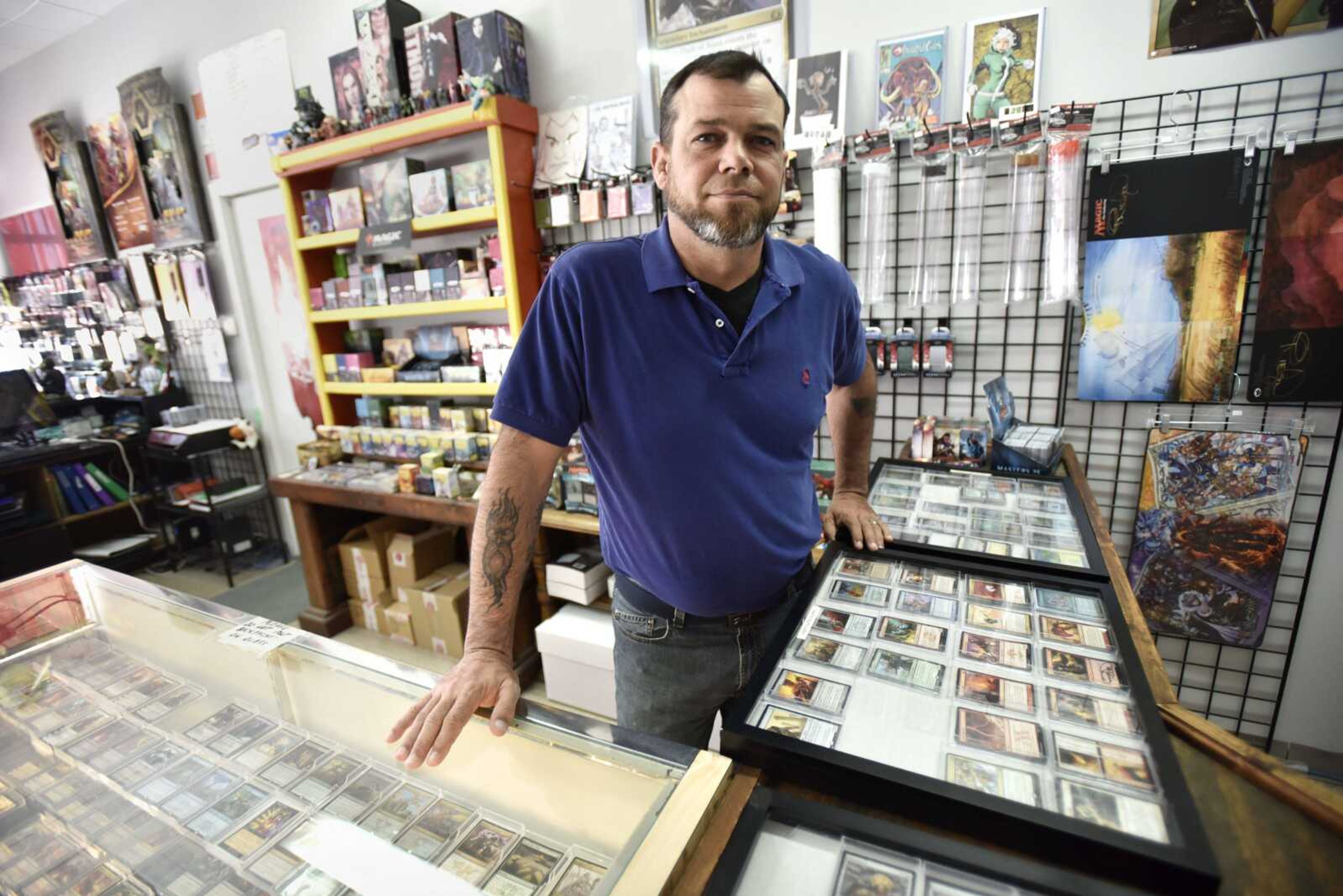 Gary Newman stands behind a counter holding Magic: The Gathering cards Thursday at KAPOW Arcade and Gaming Center in Jackson.