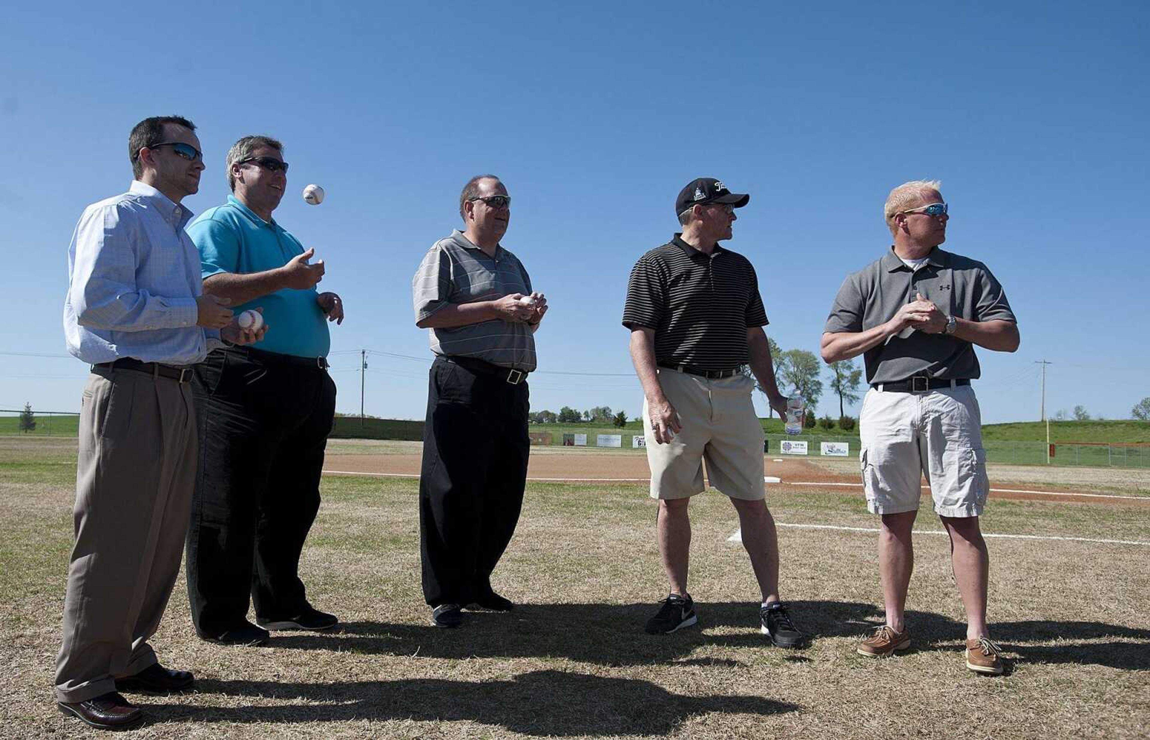 Player Greg Hellwege, left, coach Steve Williams, bench coach Chris Stanfield, pitching coach Bob Coons and player Tom Bolen of the Central High School's  1994 state champion baseball team wait to be honored before the Tigers' game against New Madrid County Central Tuesday, April 22, at central High School. (Adam Vogler)