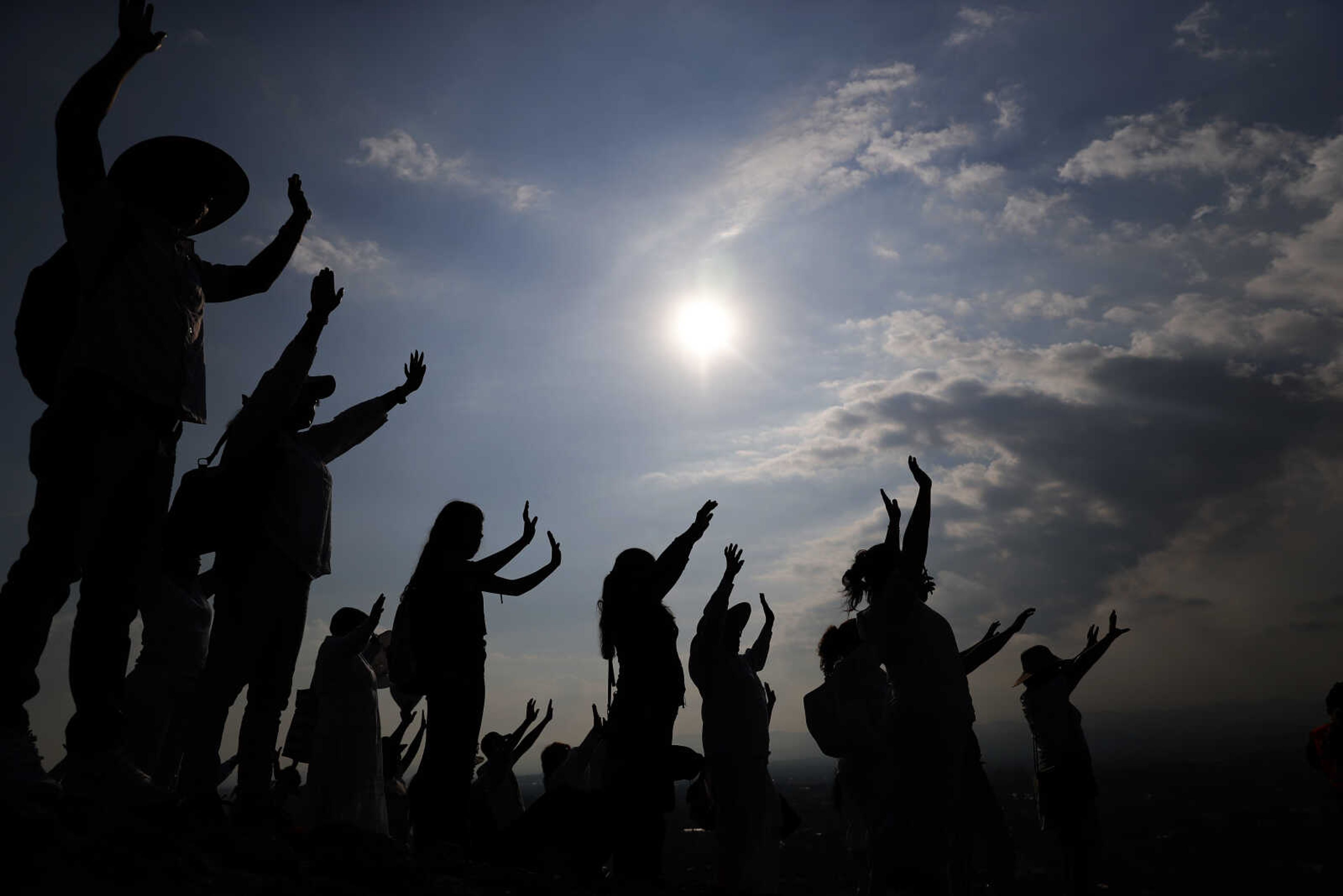 Visitors hold their hands out to receive the sun's energy as they celebrate the spring equinox atop the Pyramid of the Sun on March 21, 2019, in Teotihuacan, Mexico. Spring gets its official start Tuesday in the Northern Hemisphere. On the equinoxes, the Earth's axis and orbit line up so both hemispheres get the same amount of sunlight.