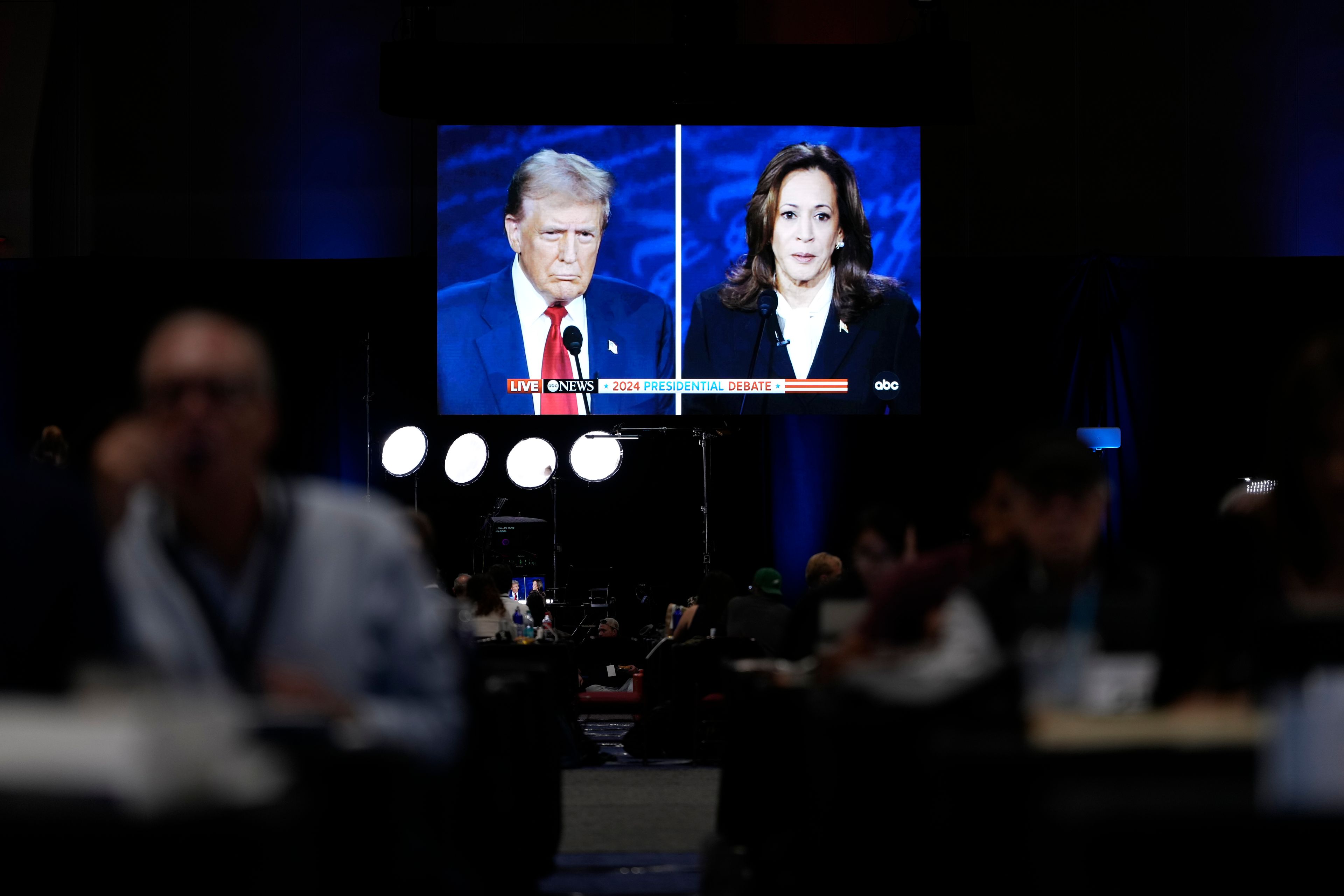 Members of the press appear in the spin room during a presidential debate between Republican presidential nominee former President Donald Trump, on screen at left, and Democratic presidential nominee Vice President Kamala Harris, right, Tuesday, Sept. 10, 2024, in Philadelphia. (AP Photo/Matt Slocum)