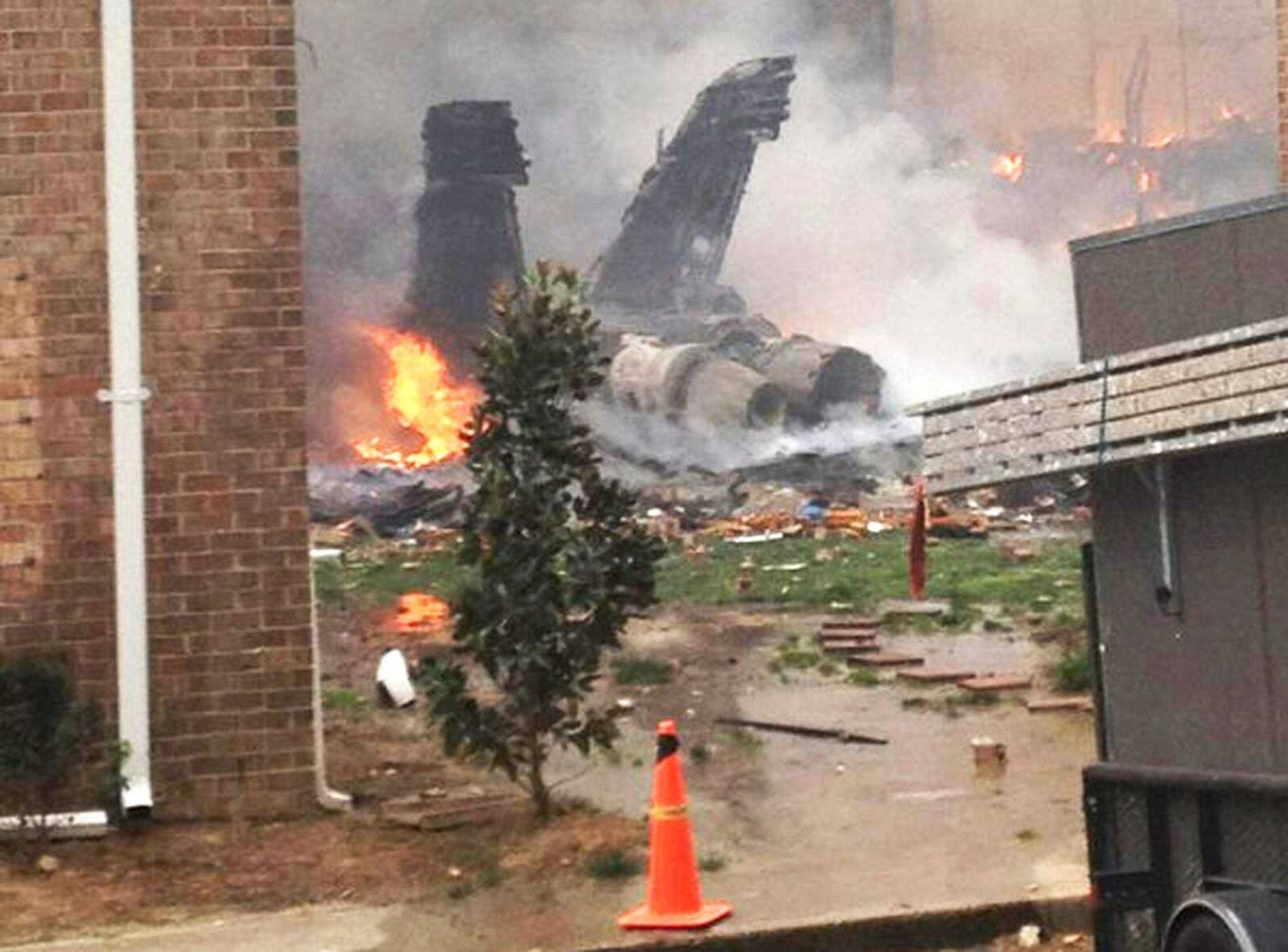 The fuselage of an F/A-18 Hornet lies burning Friday after crashing into a residential building in Virginia Beach, Va. (Zack Zapatero ~ Associated Press)