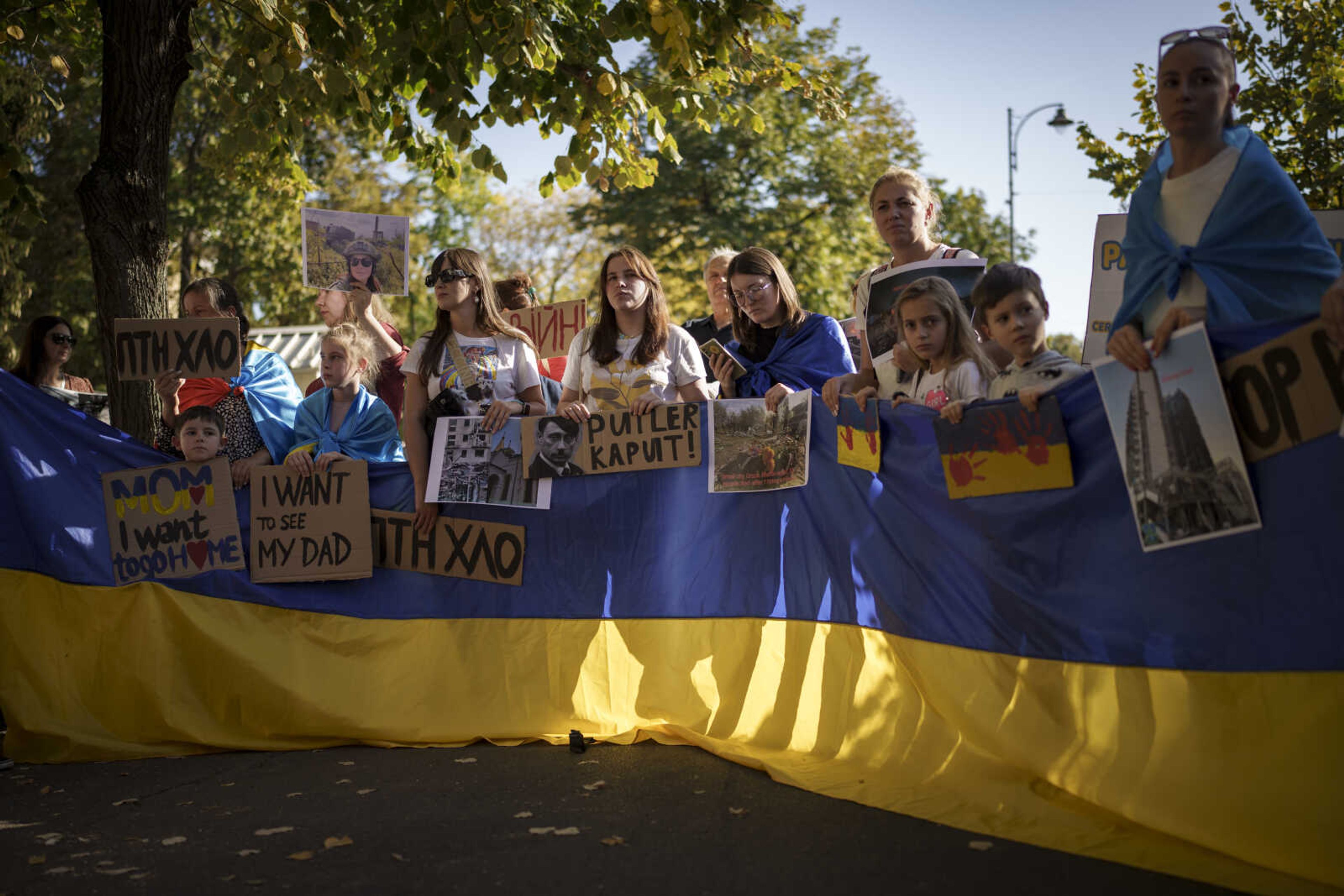 Ukrainians protest outside the Russian embassy Saturday in Bucharest, Romania. Ukrainian refugees staged the protest calling for continued western military support for their country.