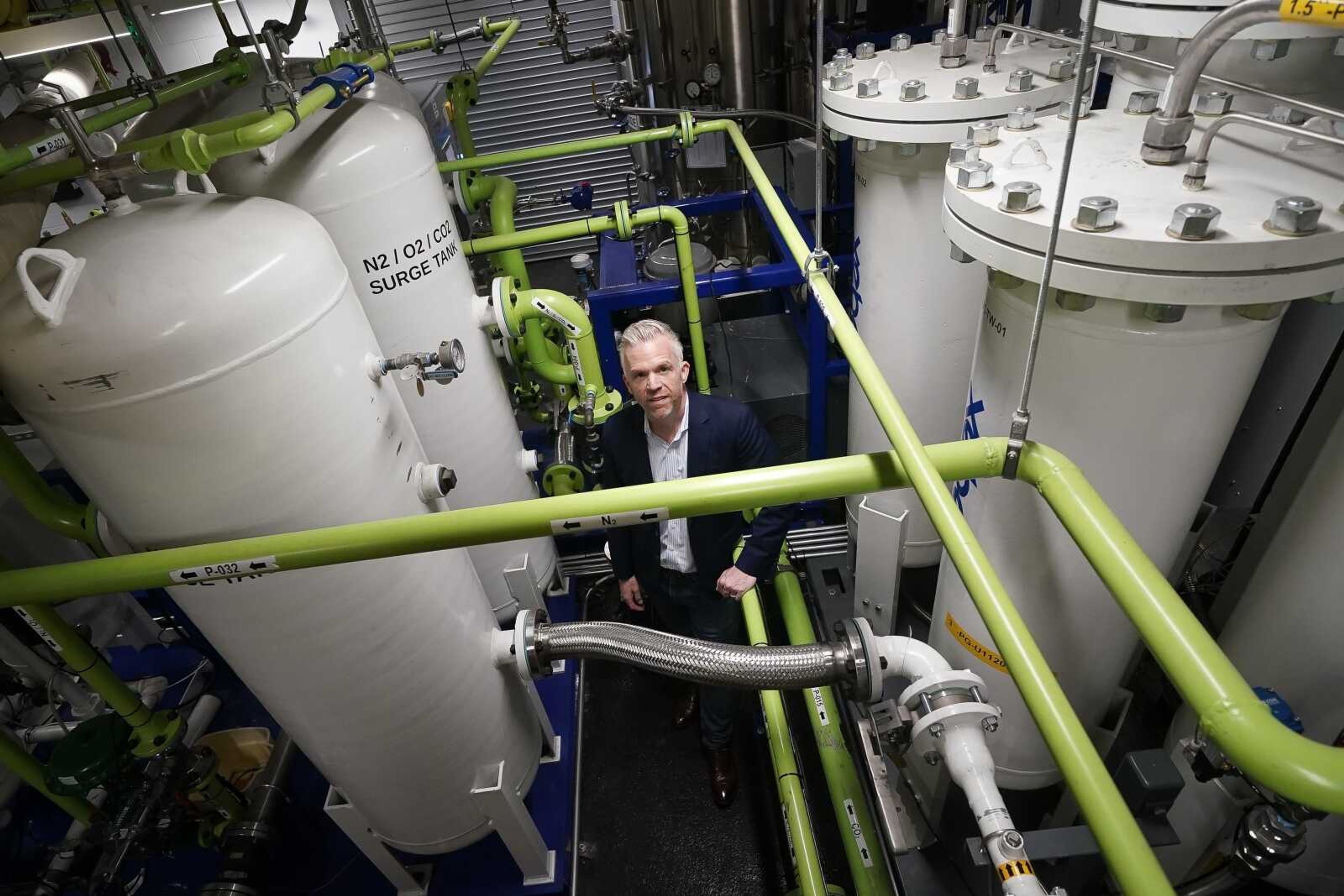 Brian Asparro, chief operating officer of CarbonQuest, stands in a production room where liquid carbon dioxide is converted from a byproduct of a natural gas fired water boiler to a salable industrial product April 18 in New York. New York is forcing buildings to clean up, and several are experimenting with capturing carbon dioxide that is emitted, cooling it into a liquid and mixing it into concrete where it turns into a mineral.