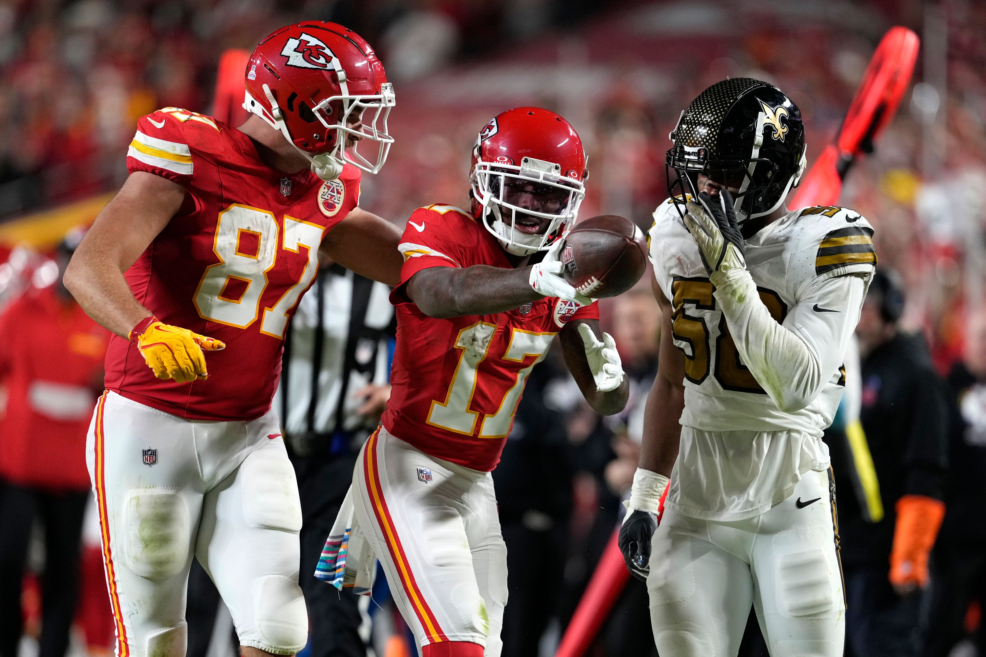 Kansas City Chiefs wide receiver Mecole Hardman (17) celebrates after gaining a first down as teammate Travis Kelce (87) and New Orleans Saints linebacker Anfernee Orji (58) watch during the second half of an NFL football game Monday, Oct. 7, 2024, in Kansas City, Mo. (AP Photo/Ed Zurga)