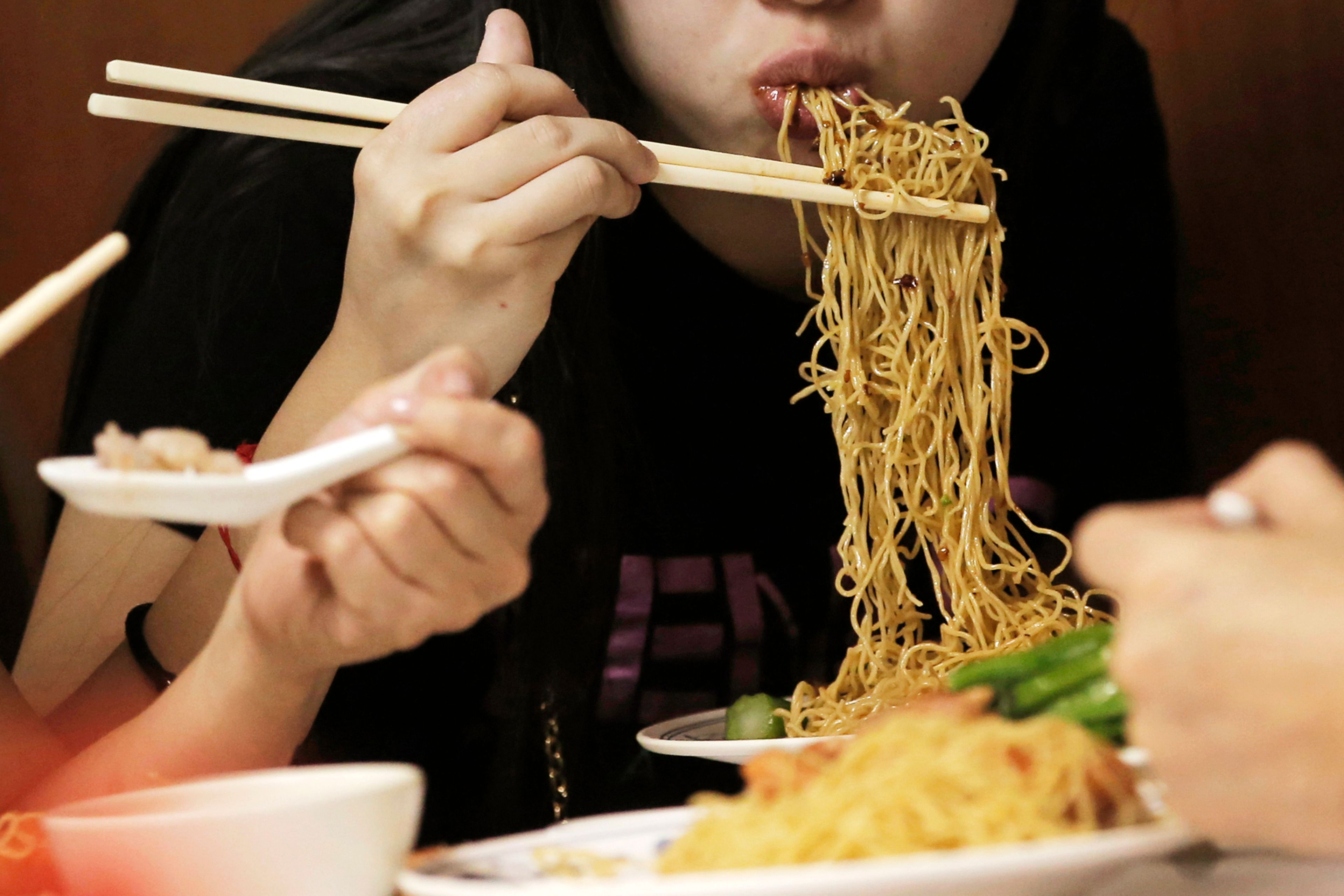 ALTERNATIVE CROP FILE - Customers eat noodles at the Wing Wah Noodle Shop in Hong Kong, on July 12, 2018. (AP Photo/Kin Cheung, File)