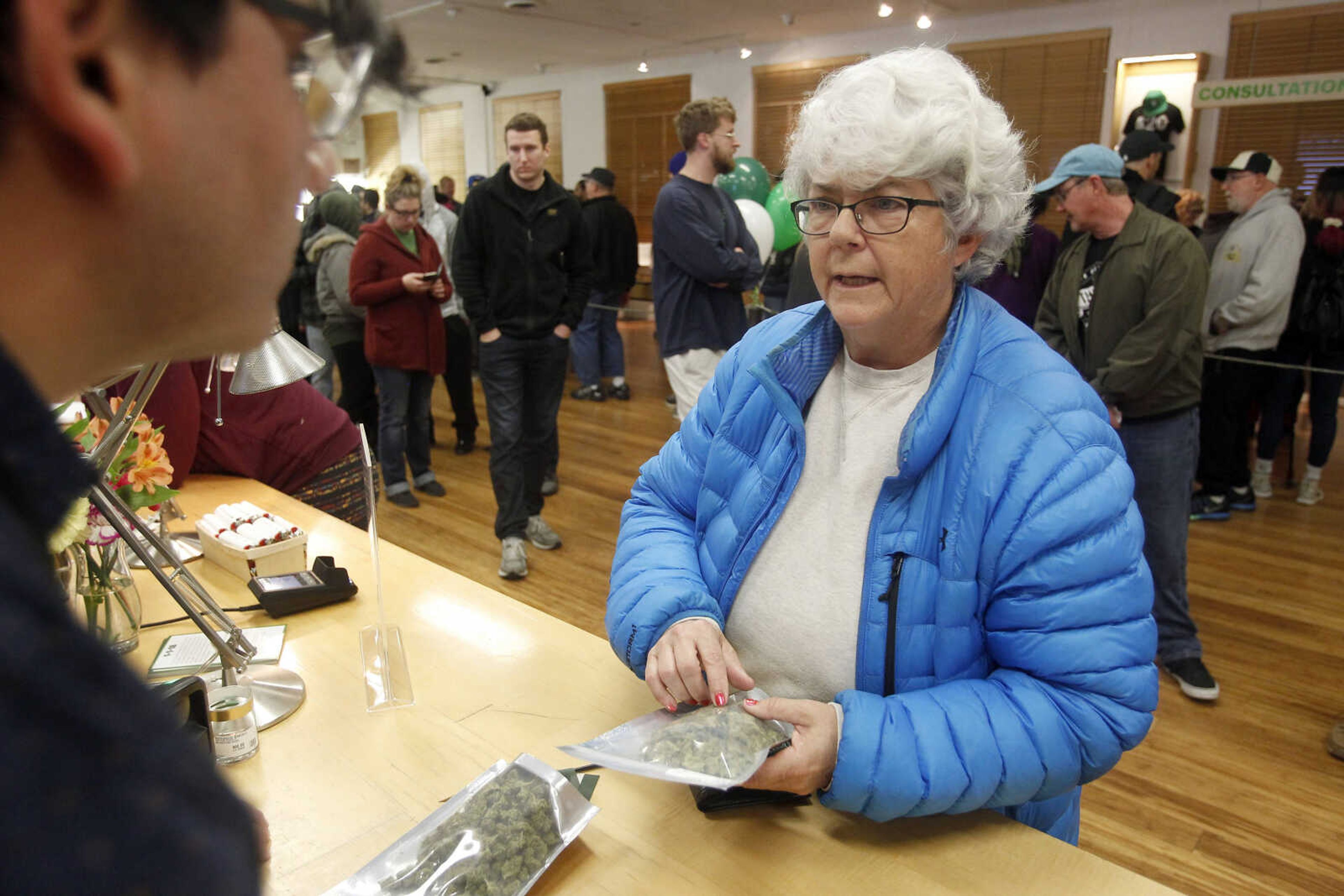 Margot Simpson, right, purchases marijuana at Harborside marijuana dispensary Monday in Oakland, California.