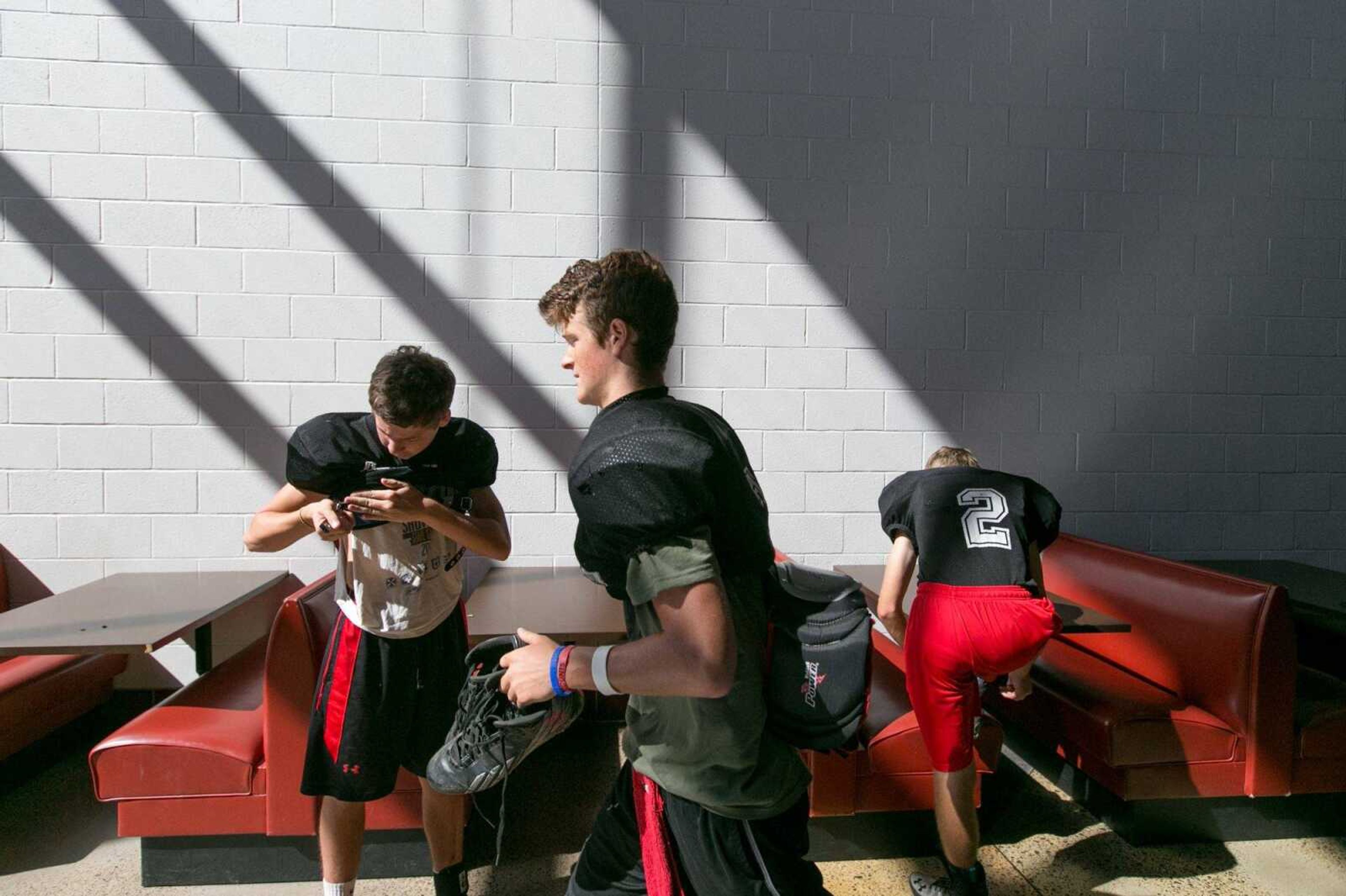 Jackson's Cooper Callis, Guthrie Hune and Jake Friedrich suit up for practice Tuesday, Aug. 11, 2015 at Jackson High School. (Glenn Landberg)