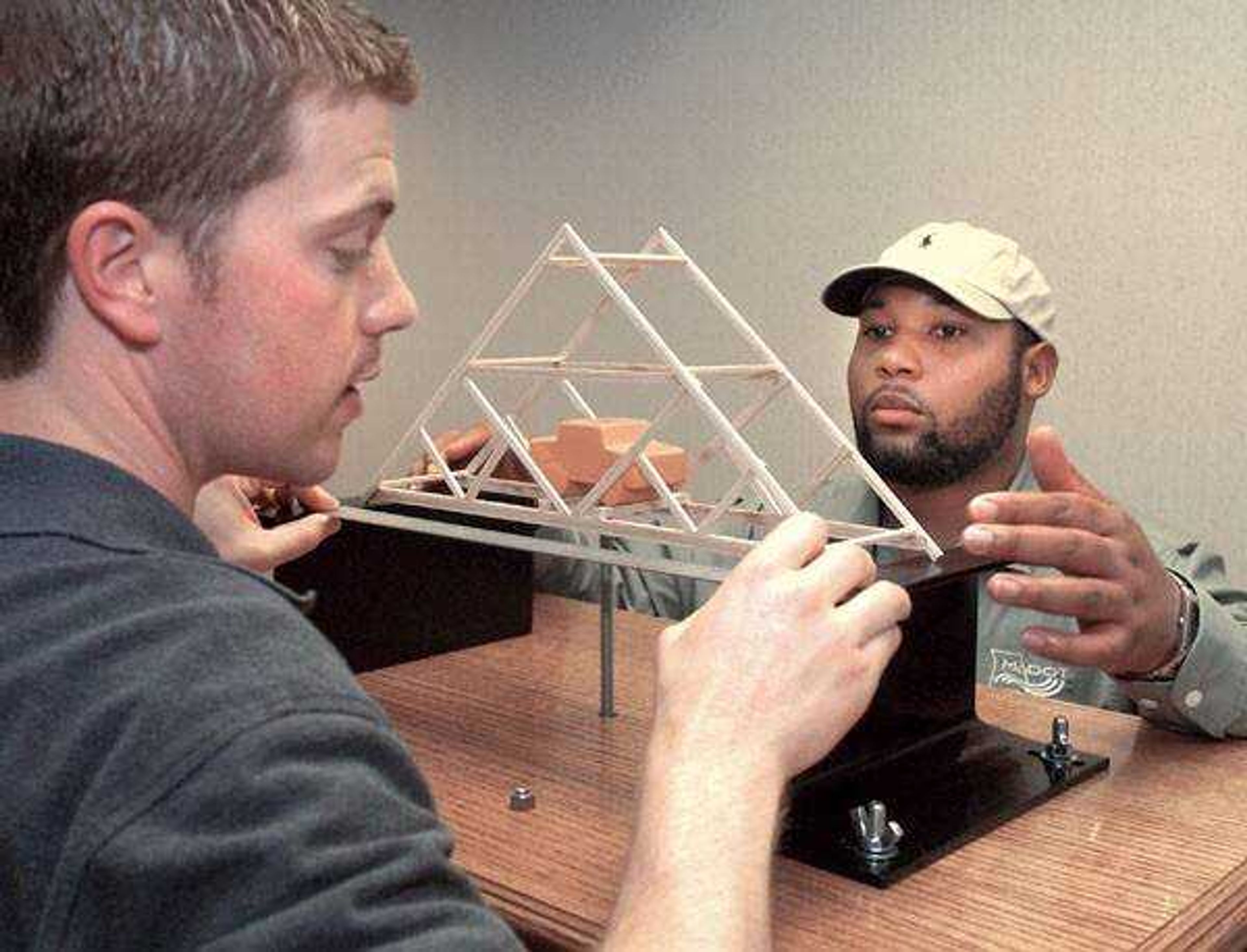 Jason Williams, left, and Kirby Woods with the Missouri Department of Transportation prepared to load-test a bridge model in the second annual high school bridge building contest on Thursday. (Fred Lynch)