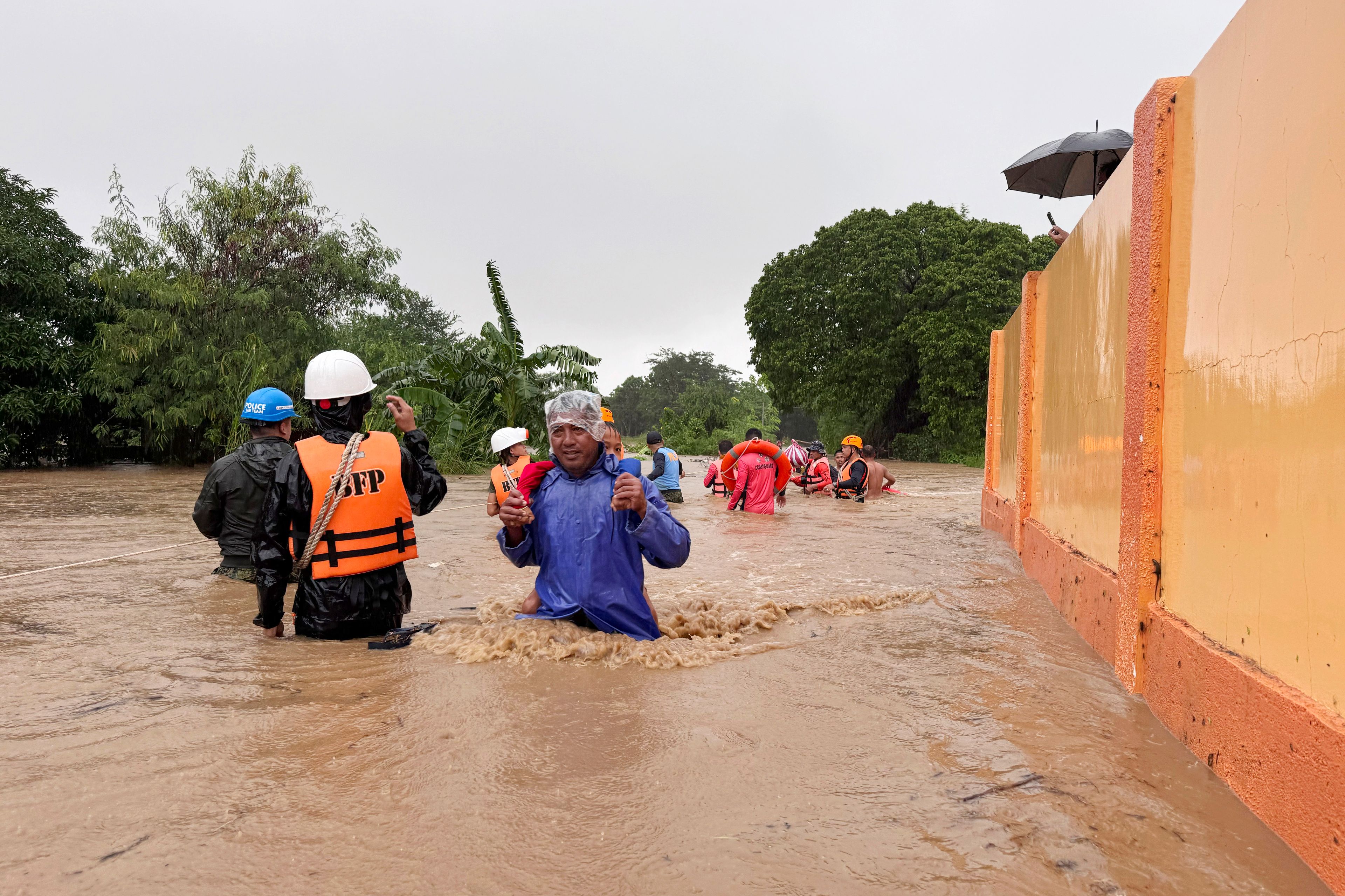 Residents negotiate floods caused by powerful Typhoon Krathon locally called "Typhoon Julian" at Bacarra, Ilocos Norte province, northern Philippines on Monday, Sept. 30, 2024. (AP Photo/Bernie Dela Cruz)