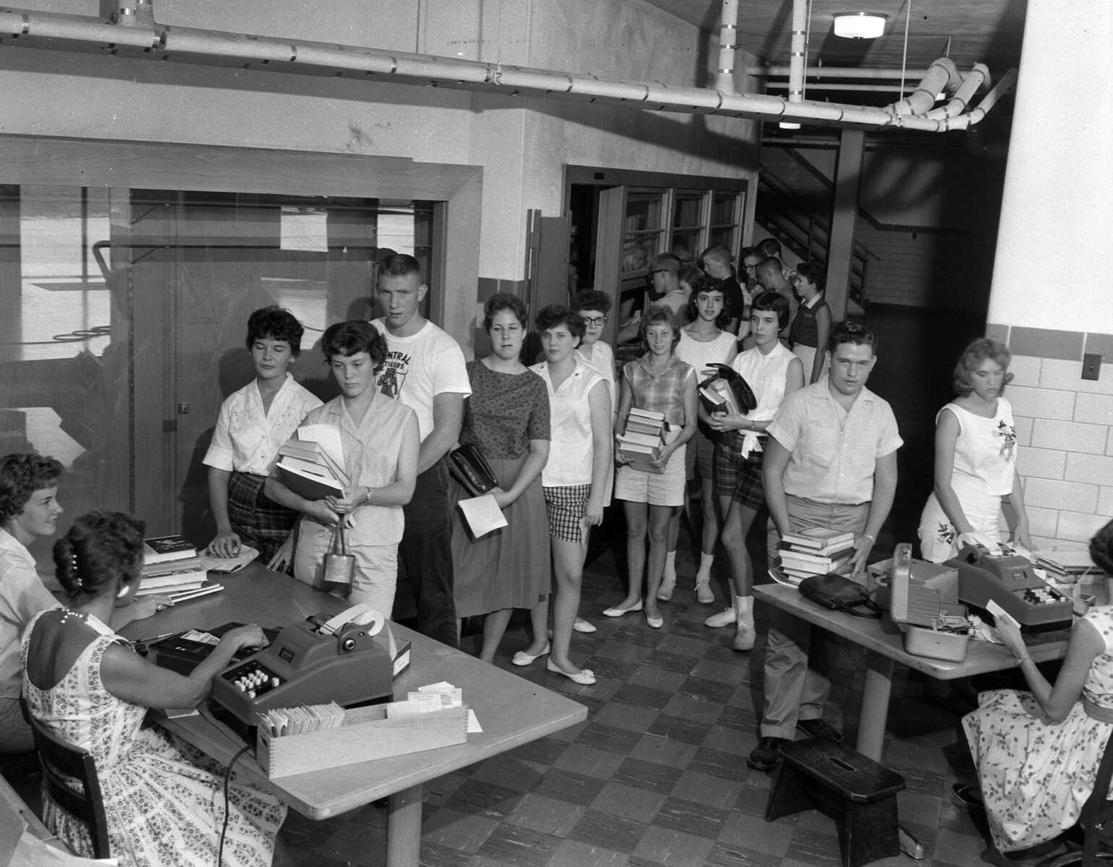 Aug. 26, 1960 Southeast Missourian.
School bells will ring again in a few days, and these Central High School juniors, getting ready for the call, are shown Thursday buying their textbooks preliminary to the actual start of school. During the past two days, long lines of the pupils have crowded the textbook area to secure their books for the fall term. Cape public schools open on Sept. 6. (G.D. Fronabarger/Southeast Missourian archive)
[Bill Stone wrote: Anne Lamkin is the person seated on the left at the left table. In line in front of the left table, left to right: Bonnie Wagner, Noel Rickard, Bob Hoffman (wearing his football t-shirt), unknown, Janet Deimund, Shirley Ackman, Cheryl Feverston, and Janet Bullock. At the right table are Don Poe, Janie Verhines (over Poe's right shoulder).]