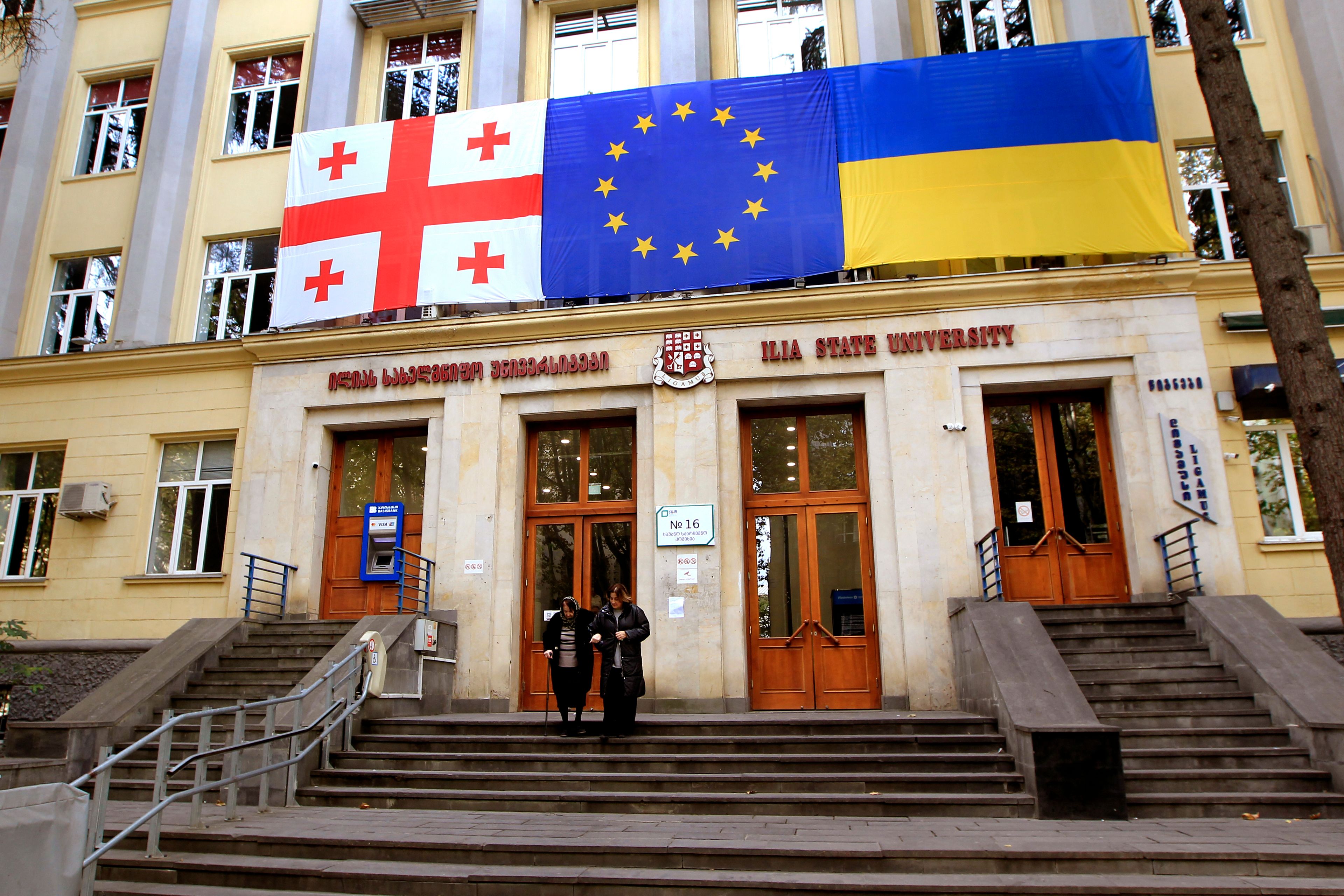 From left: Georgian national, EU and Ukrainian national flags hangs at a polling station during the parliamentary election in Tbilisi, Georgia, Saturday, Oct. 26, 2024. (AP Photo/Shakh Aivazov)