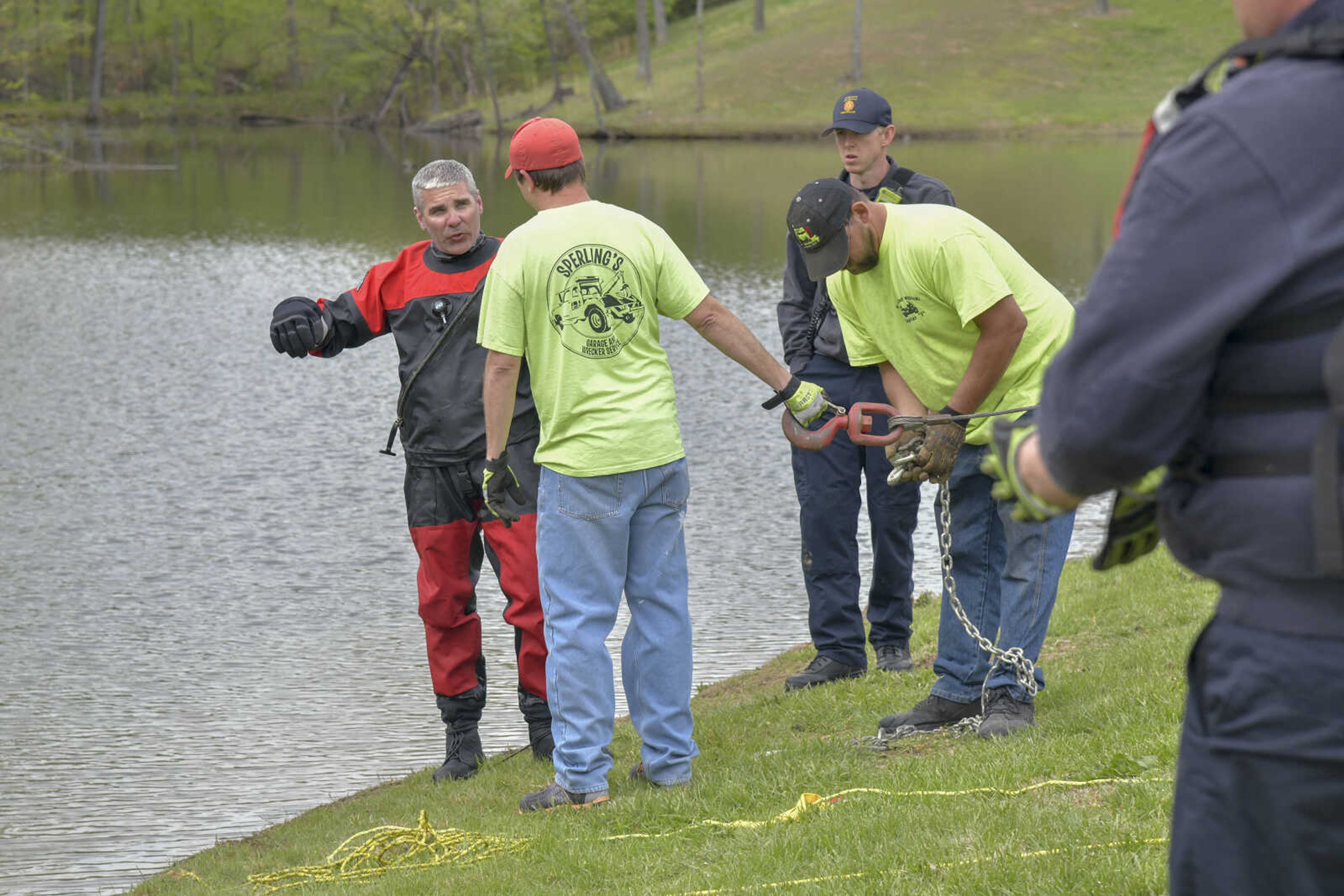 A Cape Girardeau Firefighter speaks to a worker of the tow truck before towing a submerged car in&nbsp;a pond at&nbsp;Little Ponderosa Lake near the intersection of Prospect Drive and Scenic Drive on Friday, April 16, 2021.