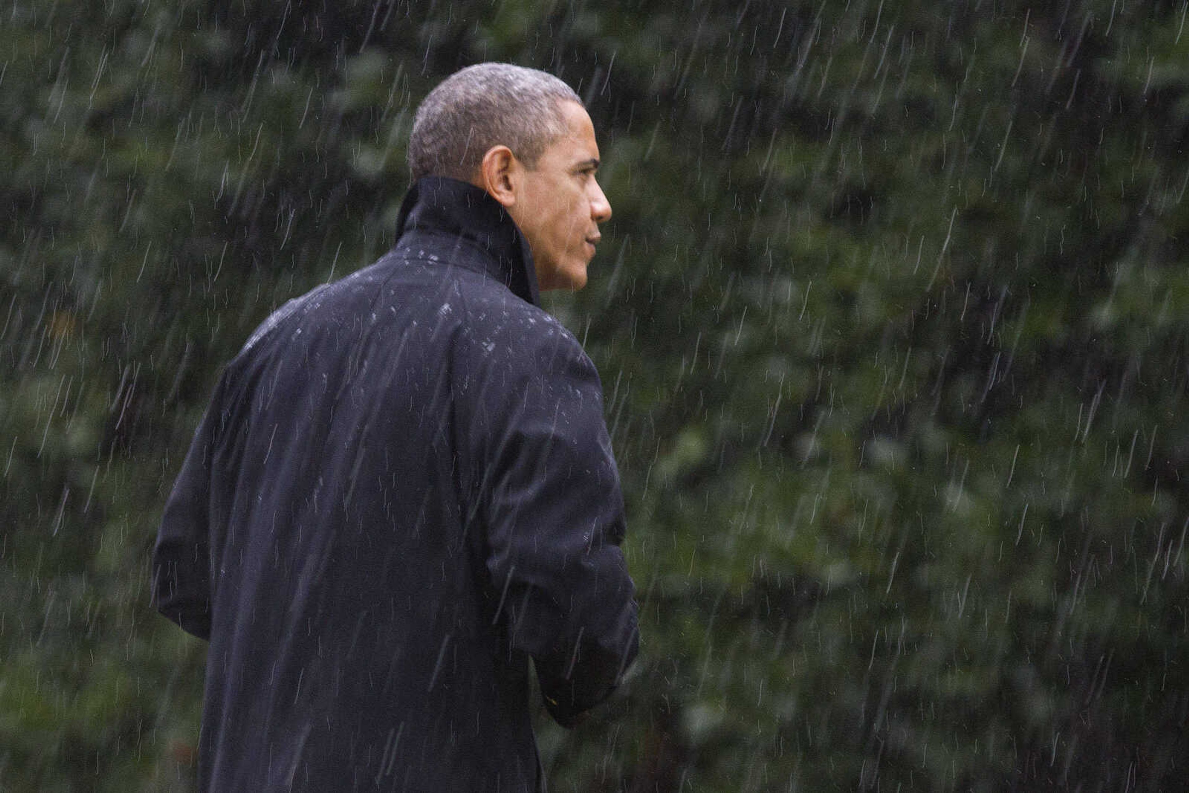 After canceling his appearance at a morning campaign rally in Orlando, Fla., President Barack Obama walks into the White House in a driving rain after returning to Washington to monitor preparations for early response to Hurricane Sandy, Monday, Oct. 29, 2012. (AP Photo/Jacquelyn Martin)