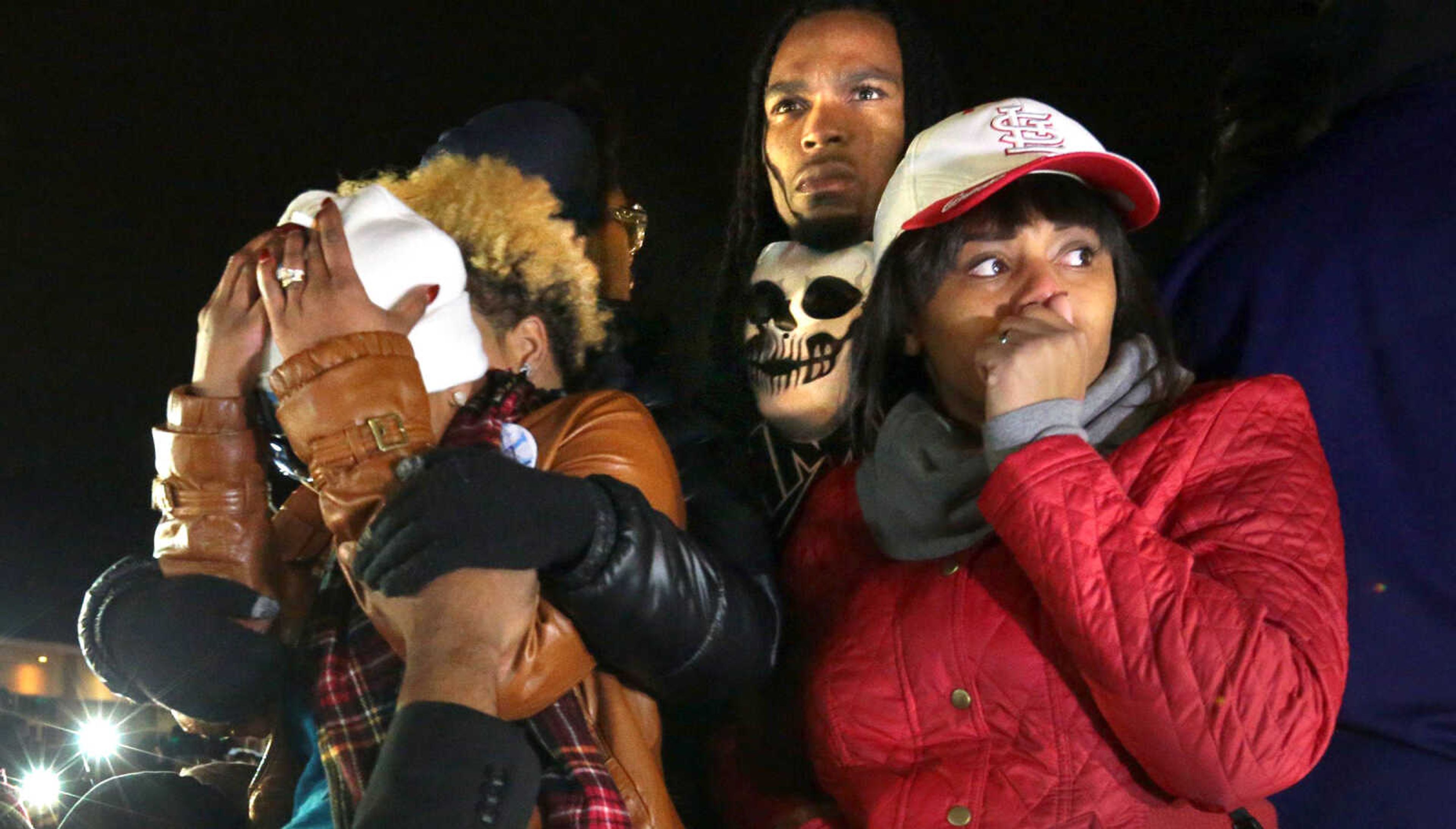 Daren Seals, center back, stands behind Lezley McSpadden, the mother of Michael Brown, as crowds stand in front of the Ferguson, Missouri, police station on Nov. 24, 2014, listening to the radio broadcast of St. Louis County Prosecutor Bob McCulloch announcing Darren Wilson would not be indicted in the death of Brown.