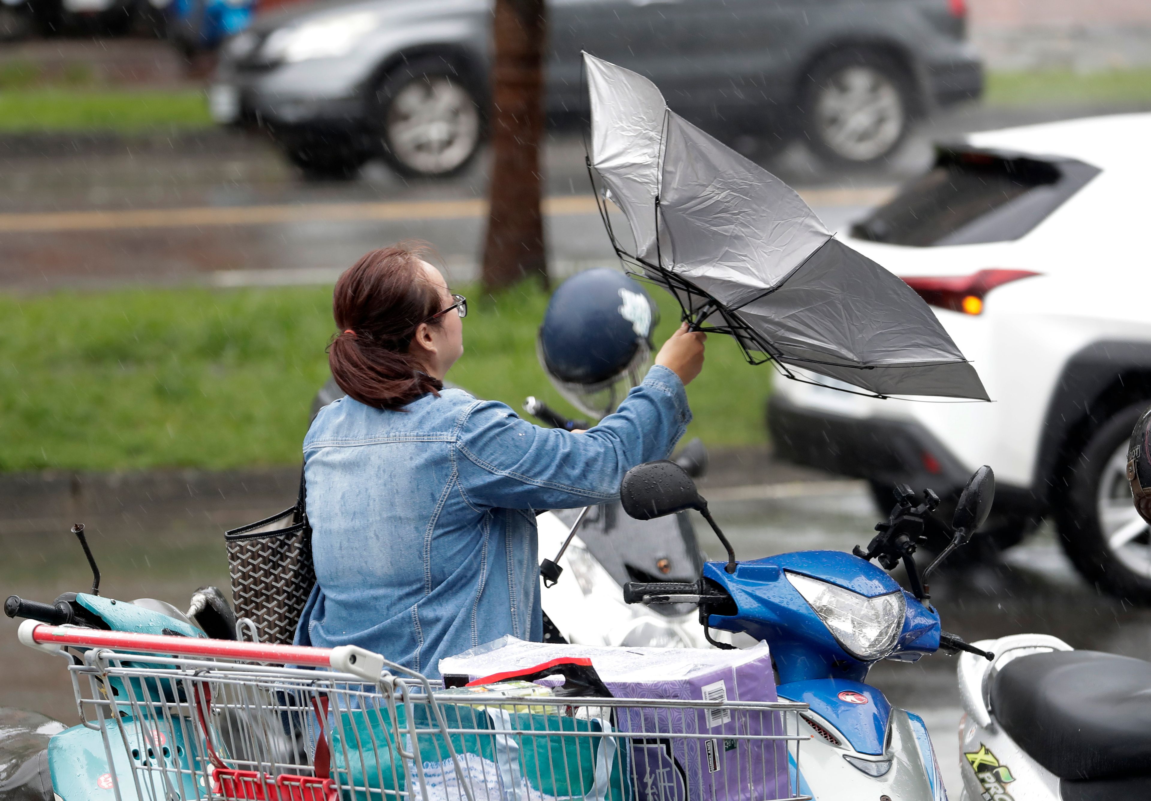 A woman struggles with winds generated by Typhoon Krathon in Kaohsiung, Southern Taiwan, Wednesday, Oct. 2, 2024. (AP Photo/Chiang Ying-ying)