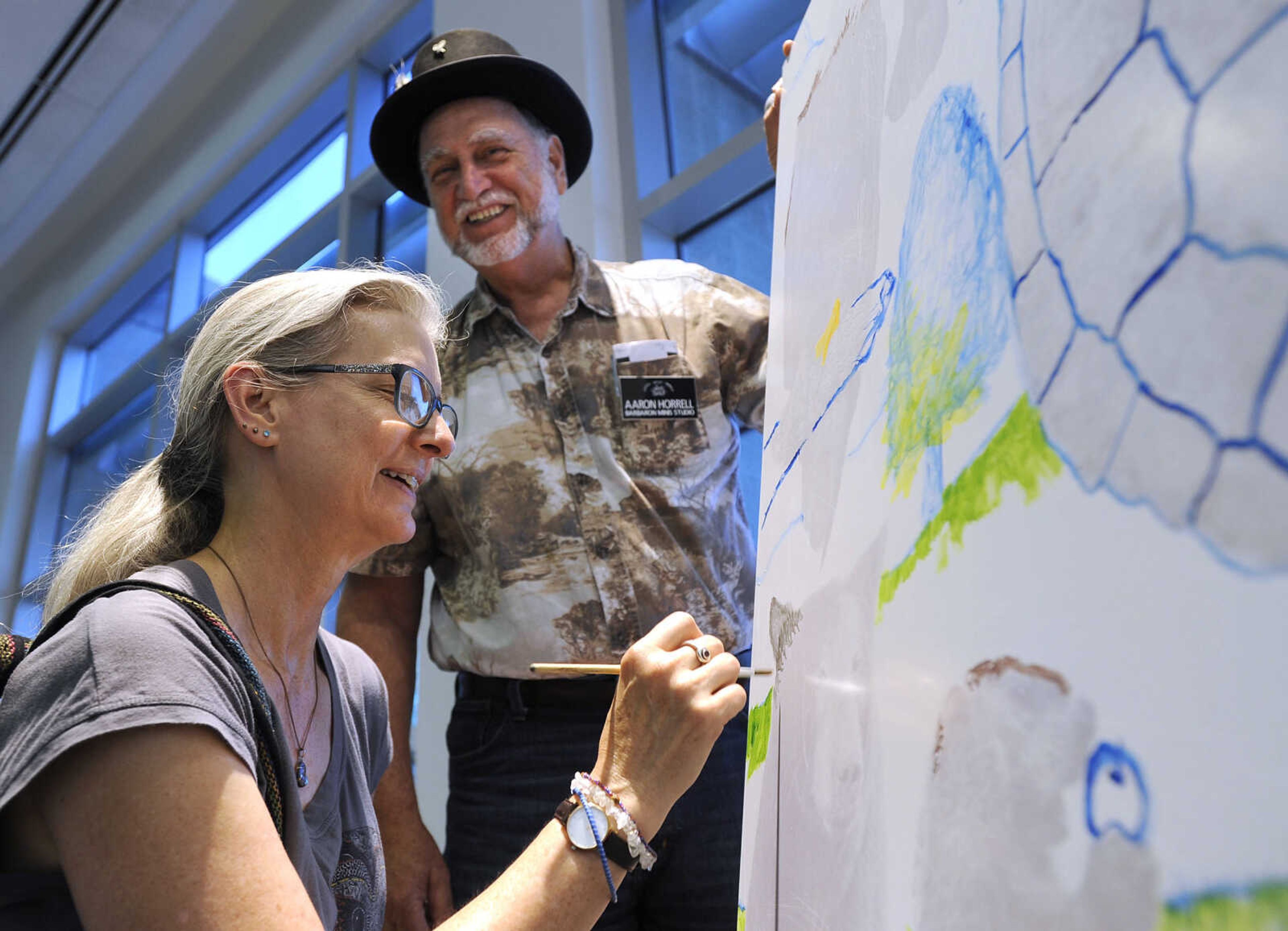 FRED LYNCH ~ flynch@semissourian.com
Donna Johnson adds her personal touch to a new Paint for a Cause painting with Aaron Horrell on Saturday, June 16, 2018 at the Summer Arts Festival at the River Campus.