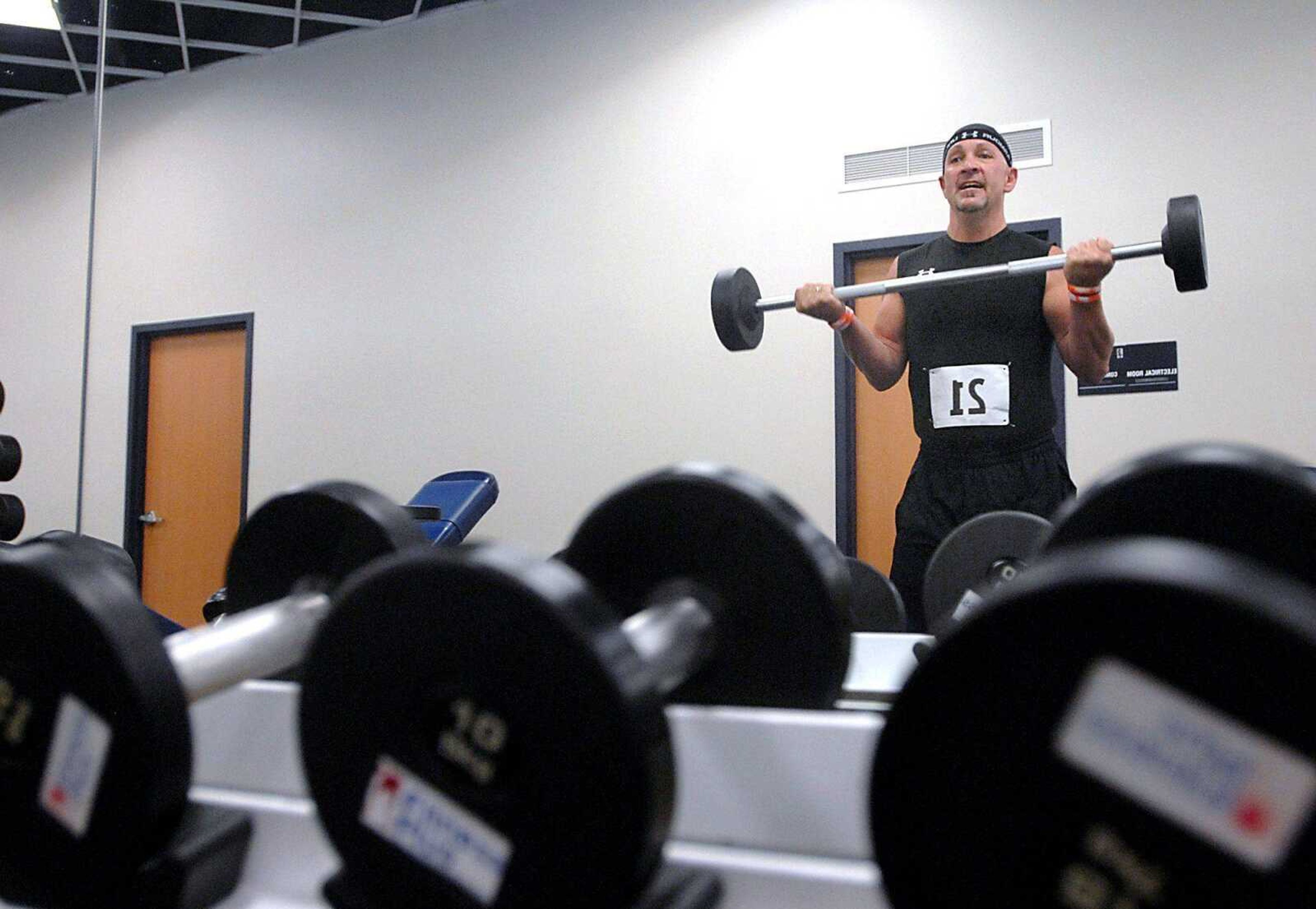 Shannon Aldridge works out Wednesday with the number 21 on him, his late daughter Sahara's basketball number, at Fitness Plus in Cape Girardeau. Aldridge said that the next week will be difficult because it is the three-year anniversary since they discovered that Sahara had cancer. (Kit Doyle)