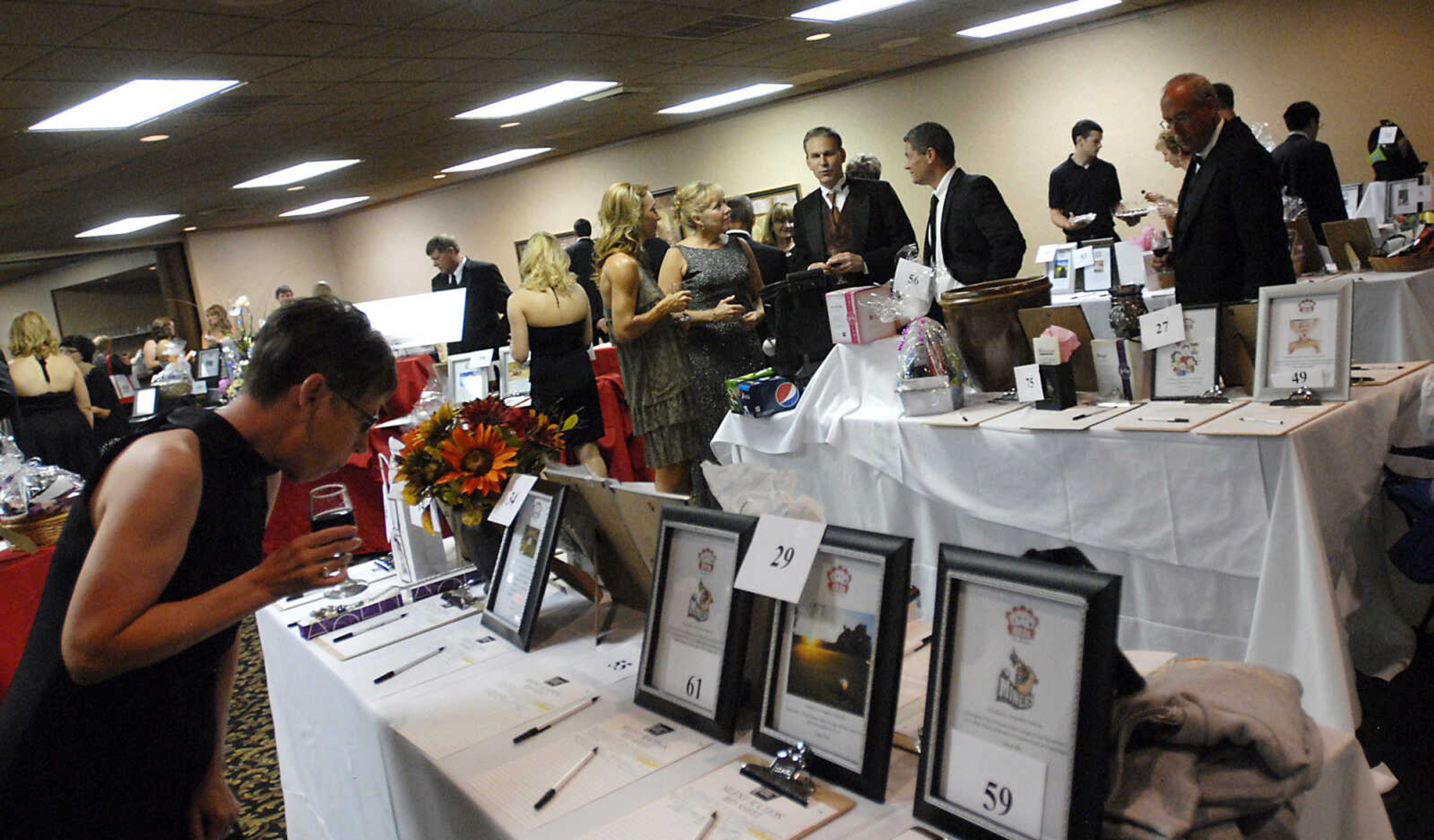 KRISTIN EBERTS ~ keberts@semissourian.com

Guests participate in the silent auction during the annual American Cancer Society Gala on Saturday, Aug. 27, 2011, at Ray's Plaza Conference Center in Cape Girardeau. This year's theme was "All-In For a Cure. "