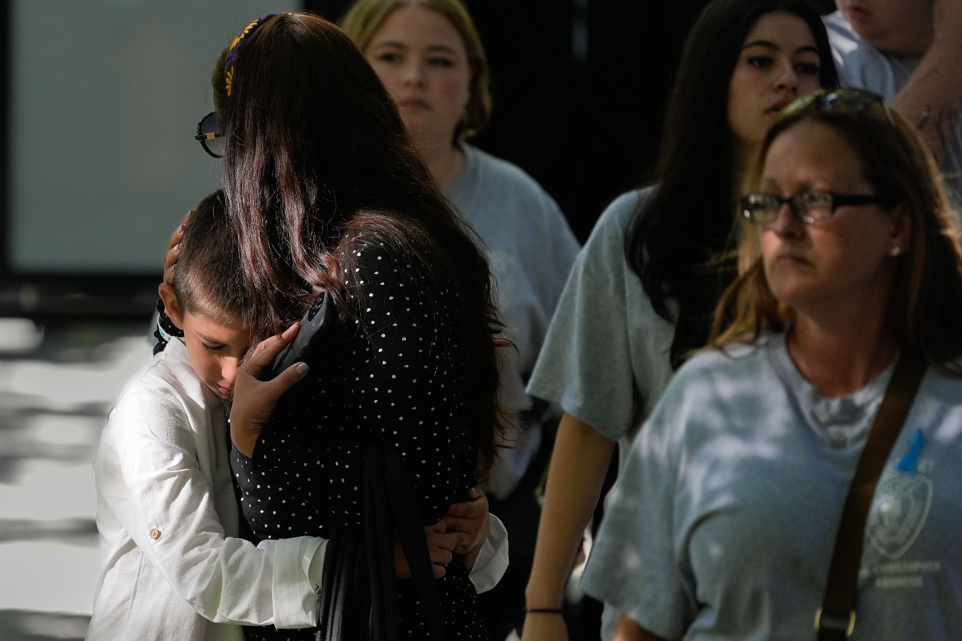 A boy hugs a woman while attending the 9/11 Memorial ceremony on the 23rd anniversary of the Sept. 11, 2001 attacks, Wednesday, Sept. 11, 2024, in New York. (AP Photo/Pamela Smith)