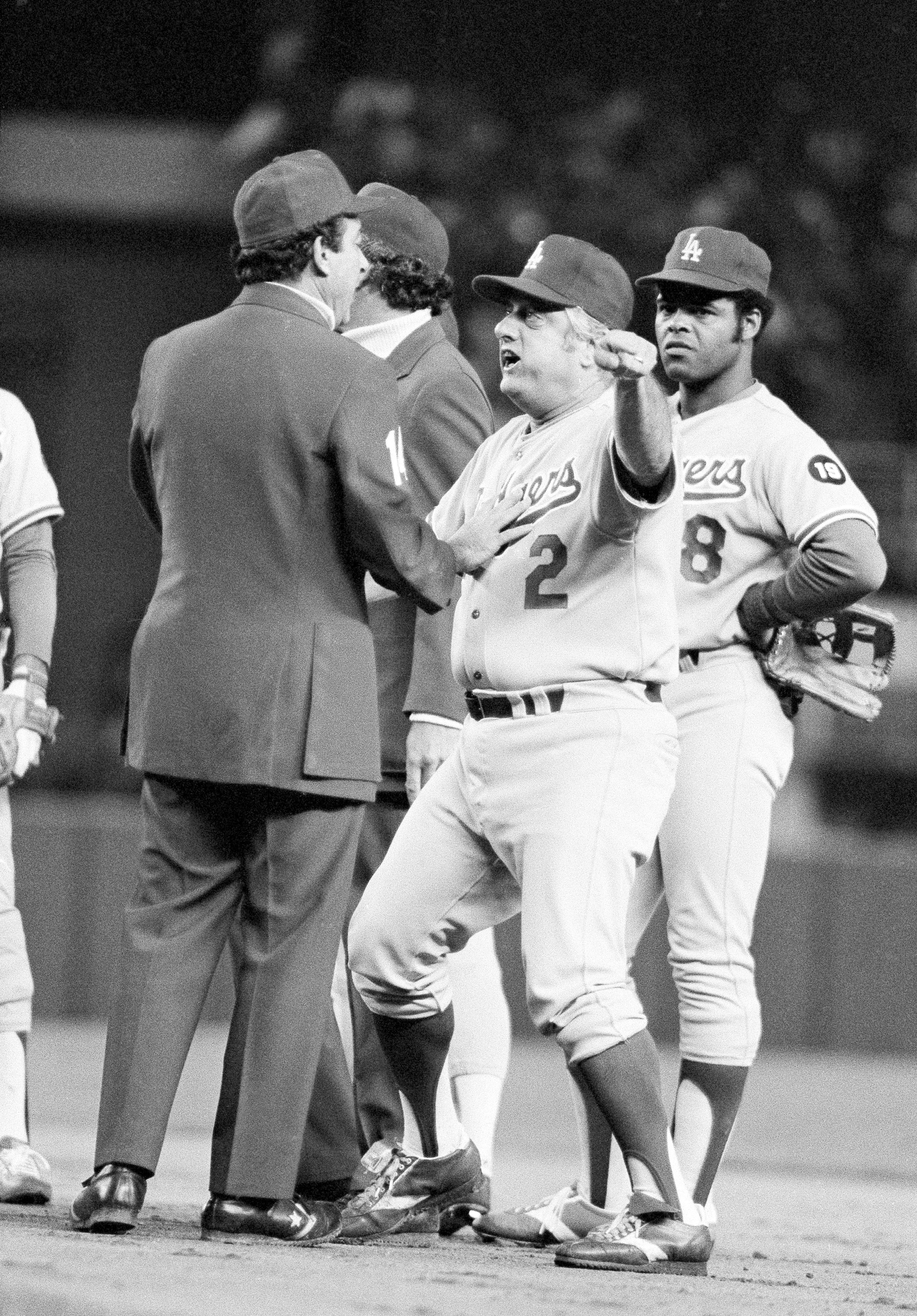 FILE - Los Angeles Dodgers manager Tom Lasorda argues with umpire Frank Pulli on a controversial play in seventh inning of aWorld Series game with the New York Yankees in New York, Saturday, Oct. 14, 1978. Lasorda argued possible interference by Yankees Reggie Jackson on a throw to first. At right is Dodgers Reggie Smith. (AP Photo/File)