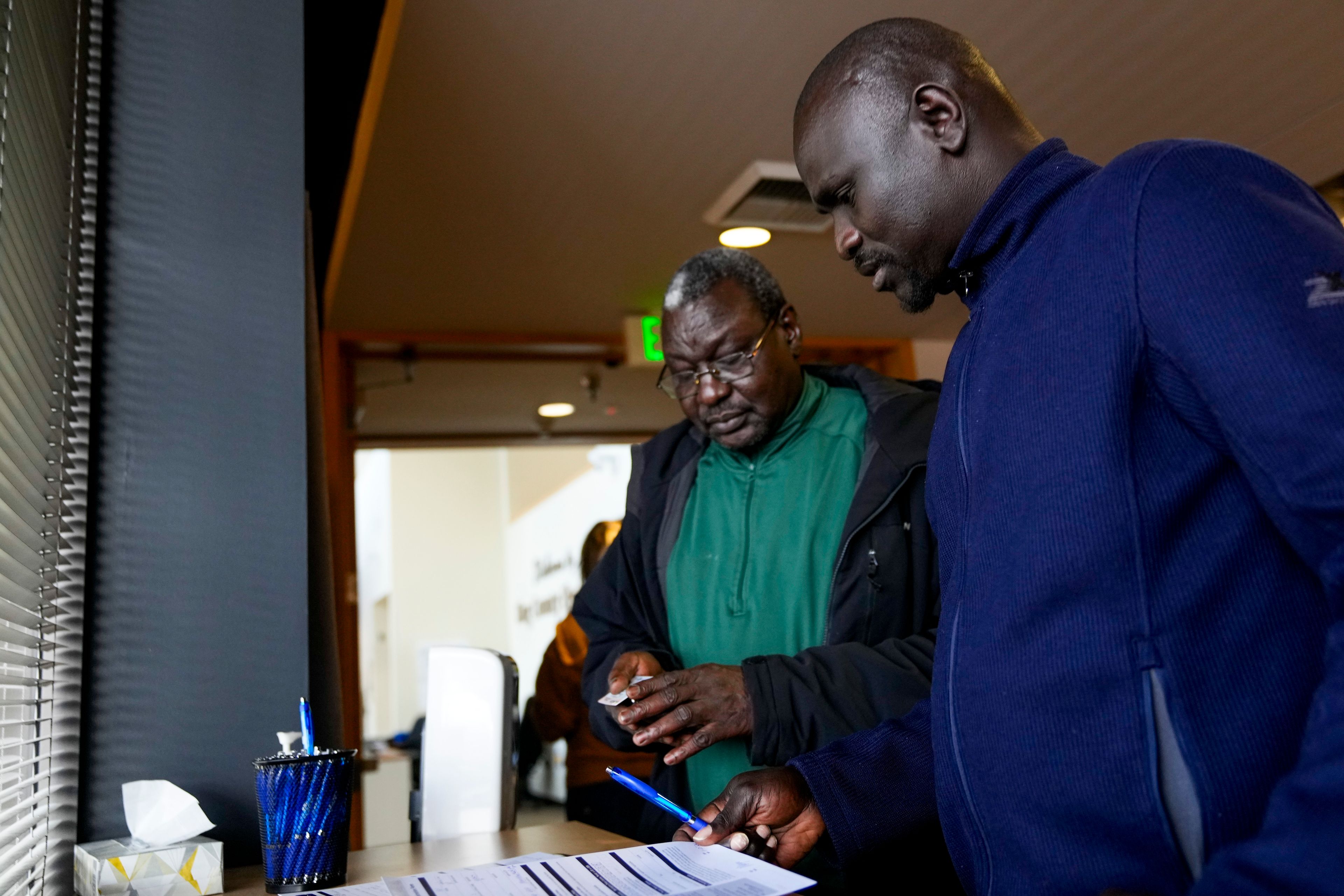 FILE - Michael Mayen, right, originally from South Sudan, registers to vote for the first time with cousin Awoul Ayom, left, at the King County Elections headquarters on Election Day, Tuesday, Nov. 5, 2024, in Renton, Wash. (AP Photo/Lindsey Wasson, File)