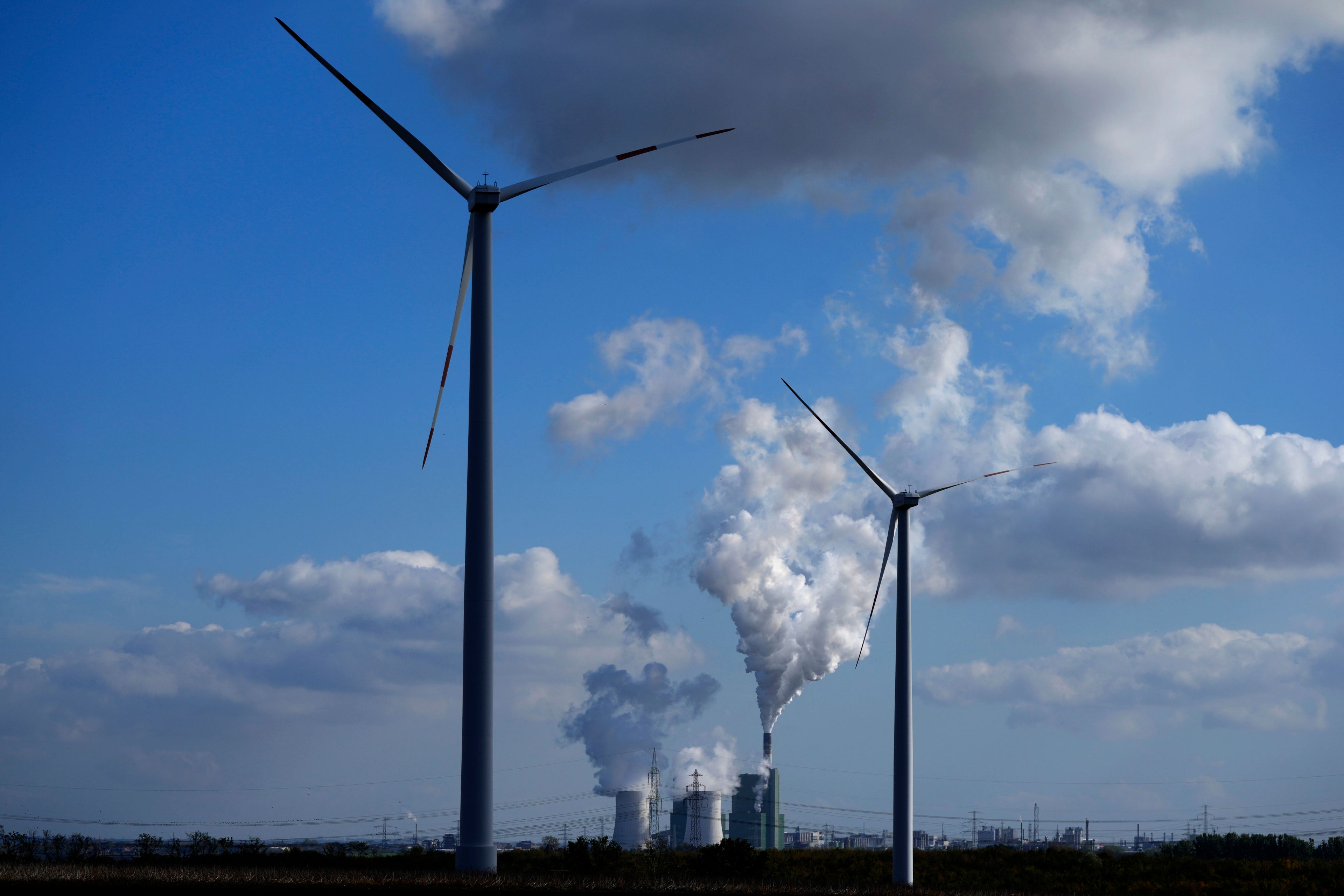 The Schkopau coal-fired power plant operates near wind turbines in Teutschenthal, near Halle, eastern Germany, Tuesday, Oct. 15, 2024. (AP Photo/Matthias Schrader)