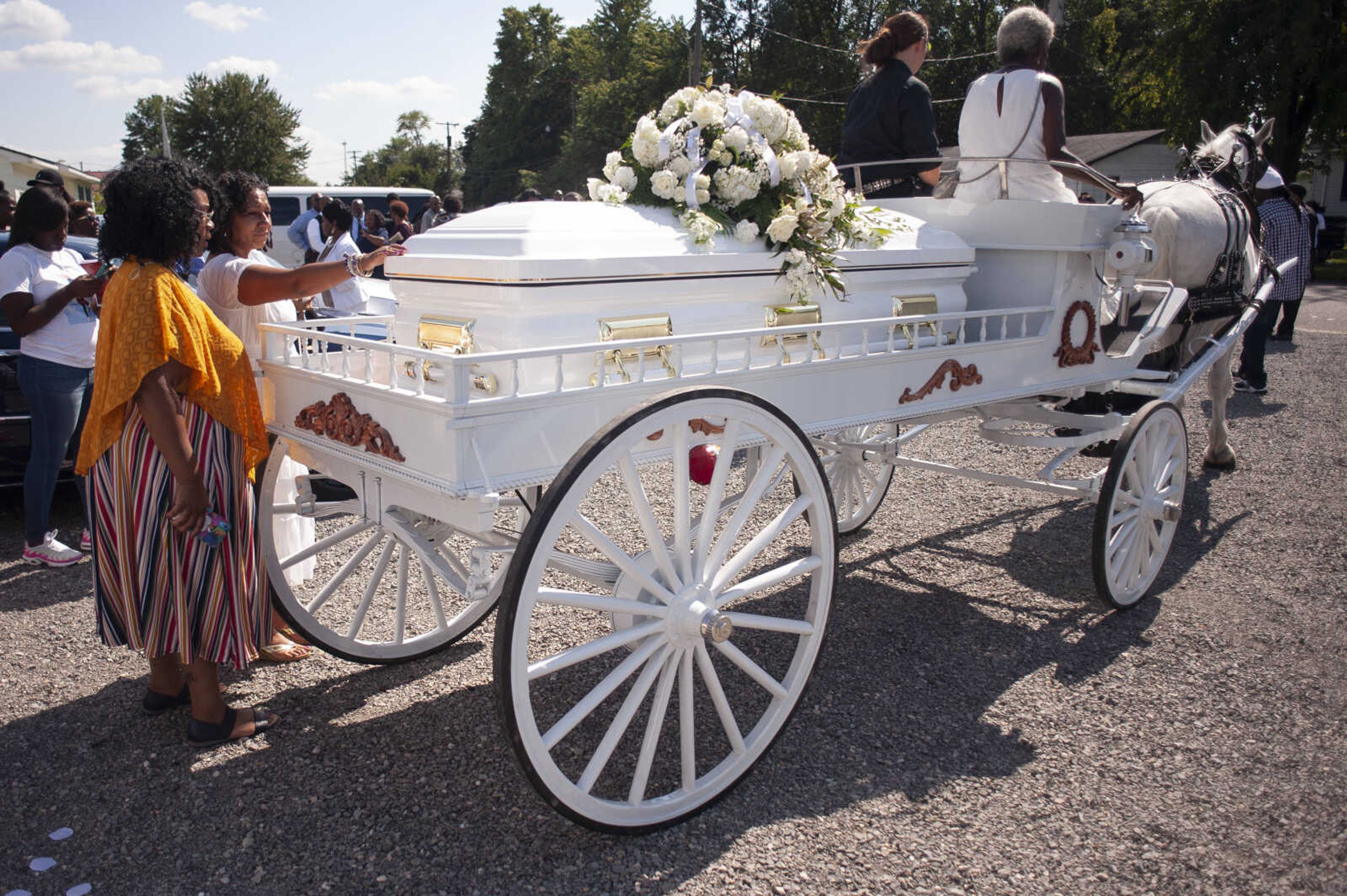 Madison Robinson's stepmother Sheila Craig places a hand on Madison's casket next to Summar Haggerty, Craig's sister, shortly after the casket was loaded to be taken to the cemetery for burial Tuesday, Sept. 3, 2019, at Mercy Seat Missionary Baptist Church in Charleston, Missouri.