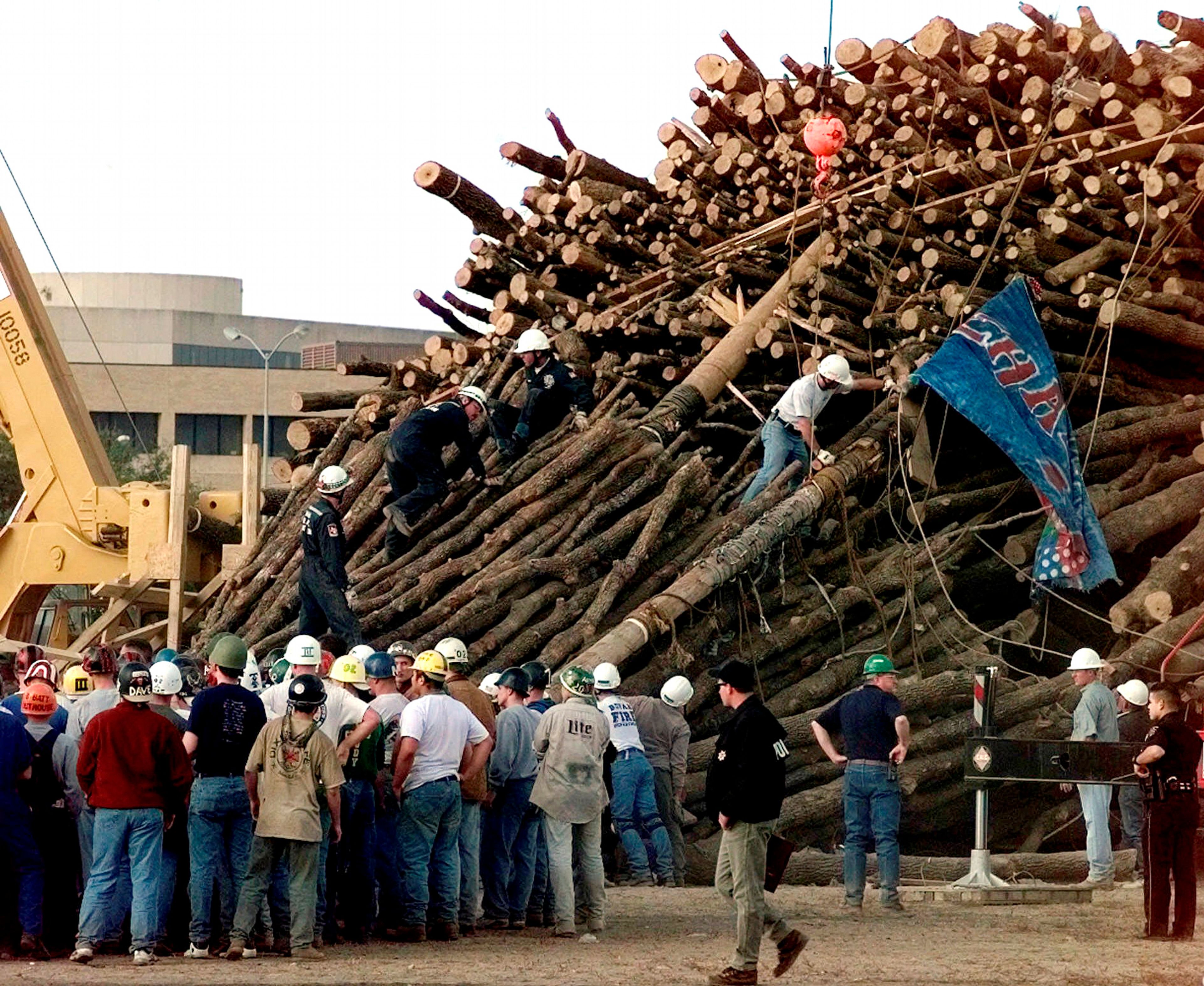 FILE - Texas A&M students and rescue workers gathered at the base of the collapsed bonfire stack as the search continues for victims in College Station, Texas, Nov. 18, 1999. (AP Photo/Pat Sullivan, File)