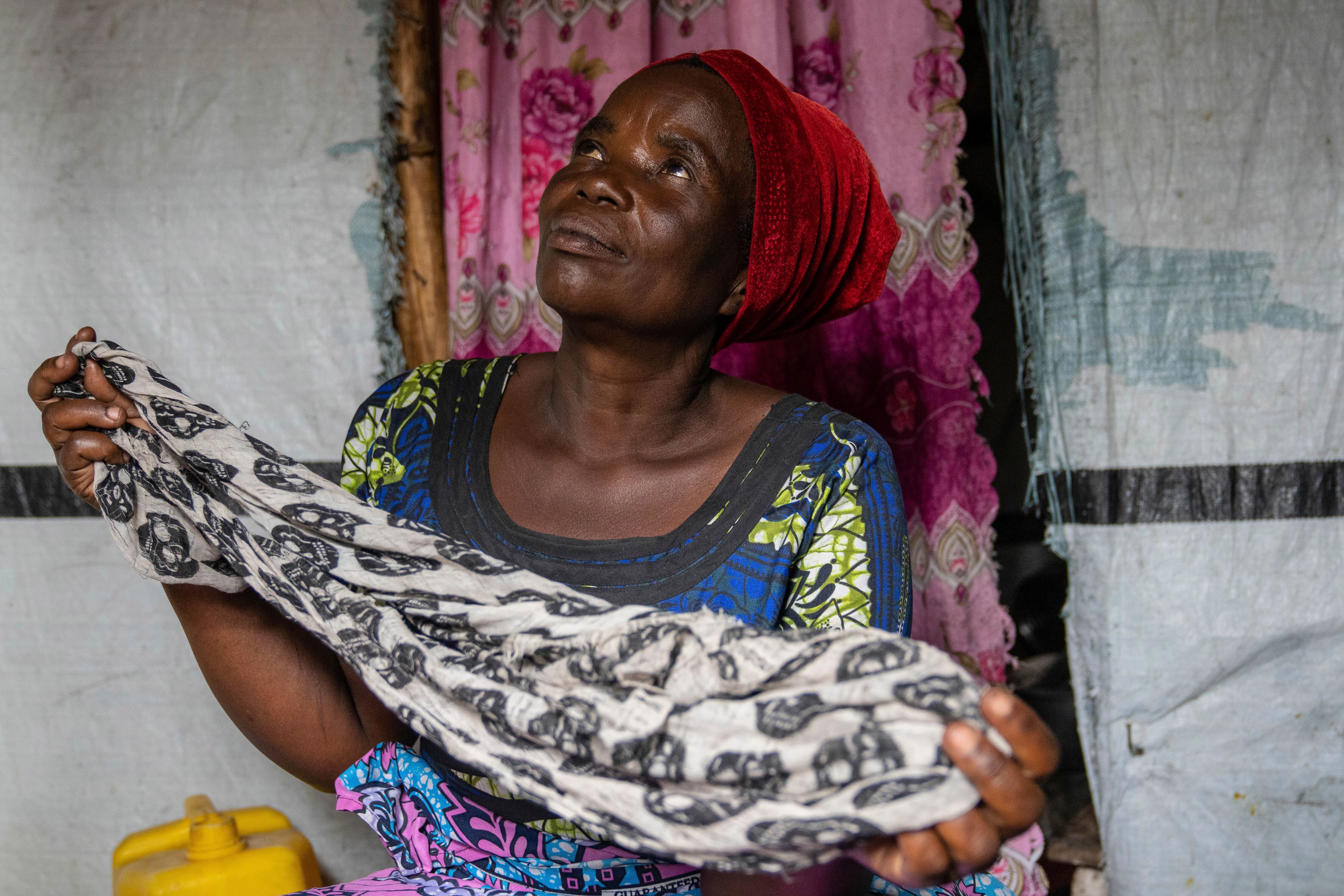 Nelly Shukuru, 51, hold the scarf she had planned on using to hang herself after spending three years displaced in the Lushagala camp in Goma, Democratic Republic of the Congo, Tuesday, Aug. 27, 2024. (AP Photo/Moses Sawasawa)