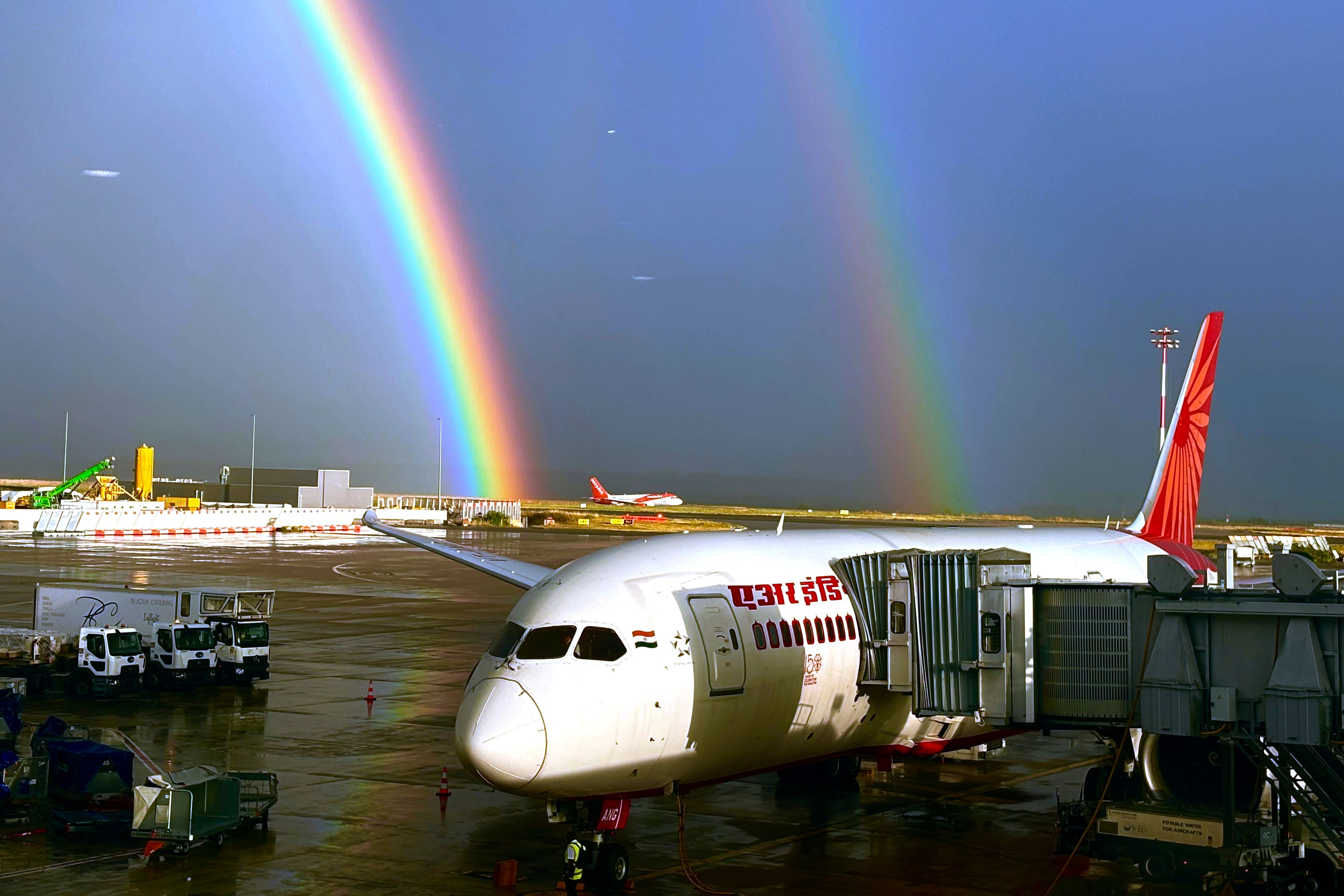 An Air India aircraft, owned by the Tata Group, is seen parked against a double rainbow formed over Charles de Gaulle Airport in Paris, France, Friday, Aug. 9, 2024. (AP Photo/Manish Swarup)