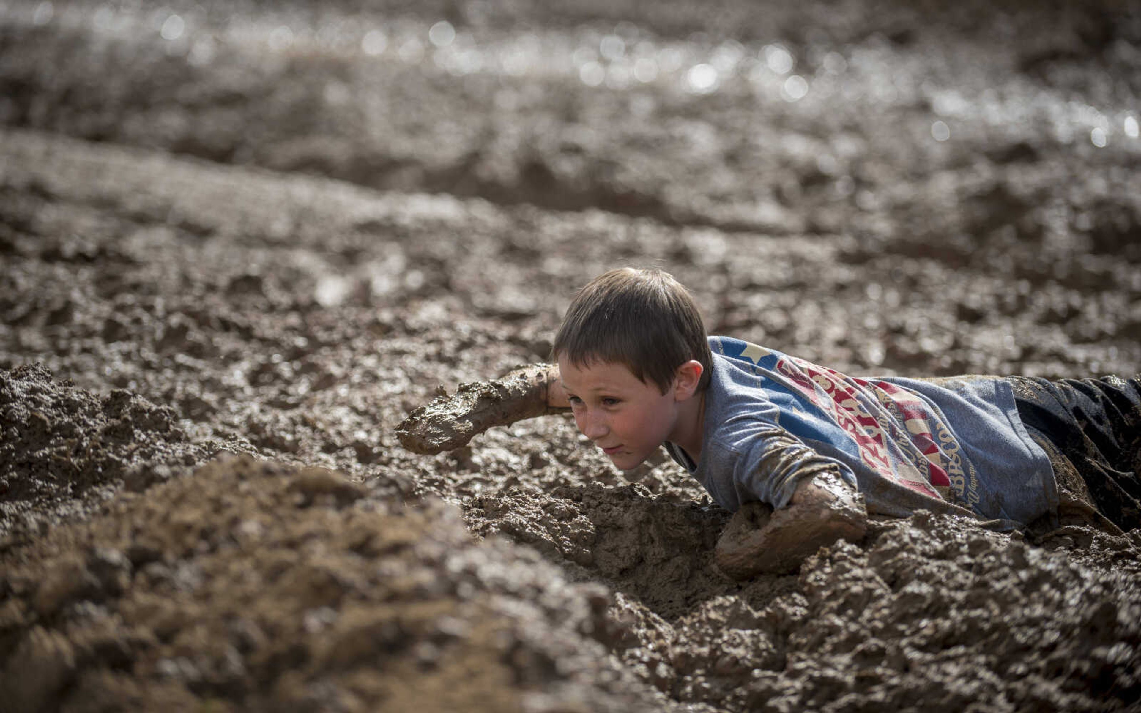 After falling during a mud race, a contestant struggles to crawl free during Benton Neighbor Days Saturday, September 1, 2018.