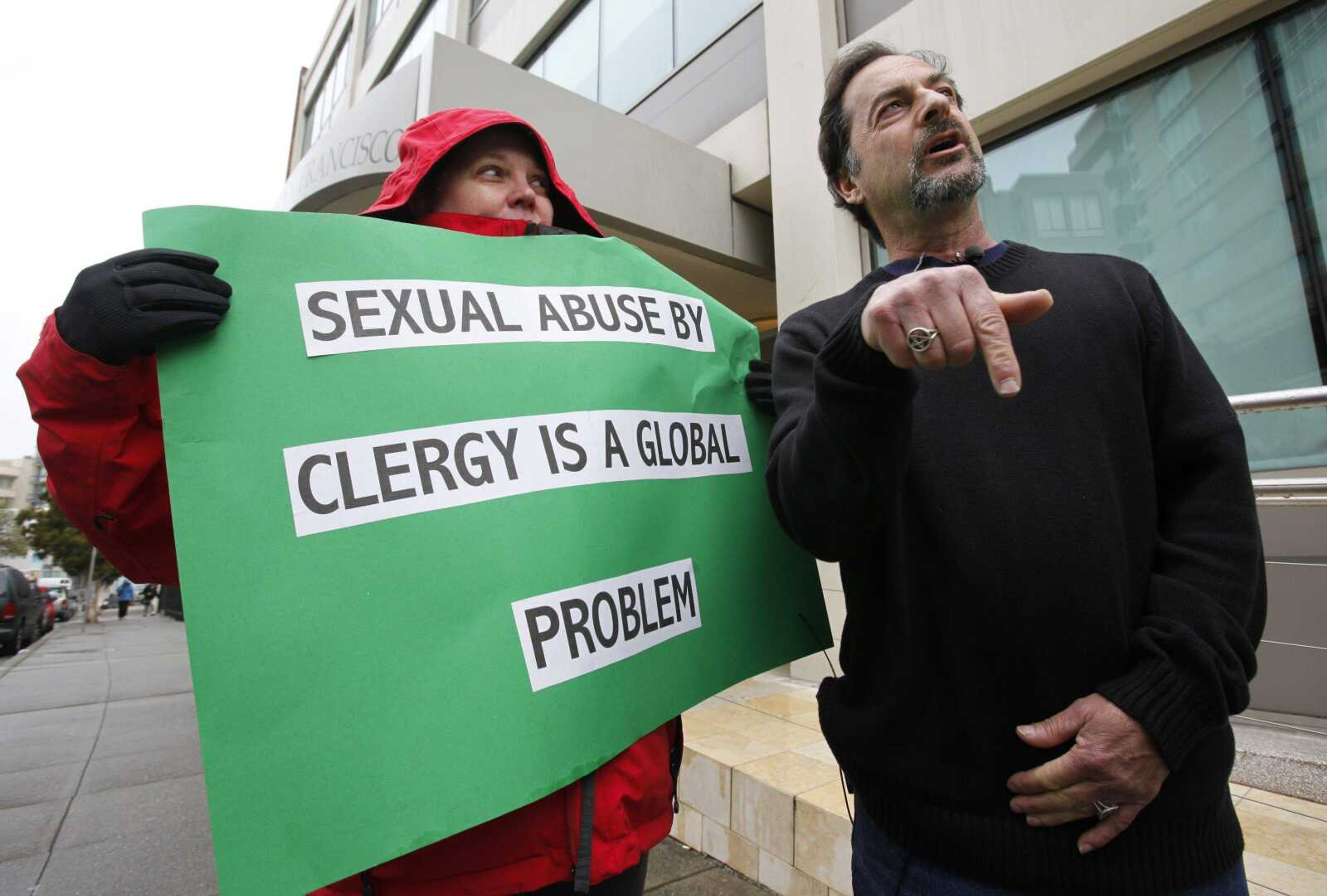 Joey Piscitelli, the Northern California director of SNAP (the Survivors Network of those Abused by Priests) who says he was sexually abused by a priest, talks about Pope Benedict XVI, as Melanie Sakoda, left, holds a sign during a news conference Monday at a demonstration in front of the archdiocese headquarters in San Francisco. The demonstration was held against the Catholic Church about sexual abuse remarks made by Pope Benedict XVI. (PAUL SAKUMA ~ Associated Press)