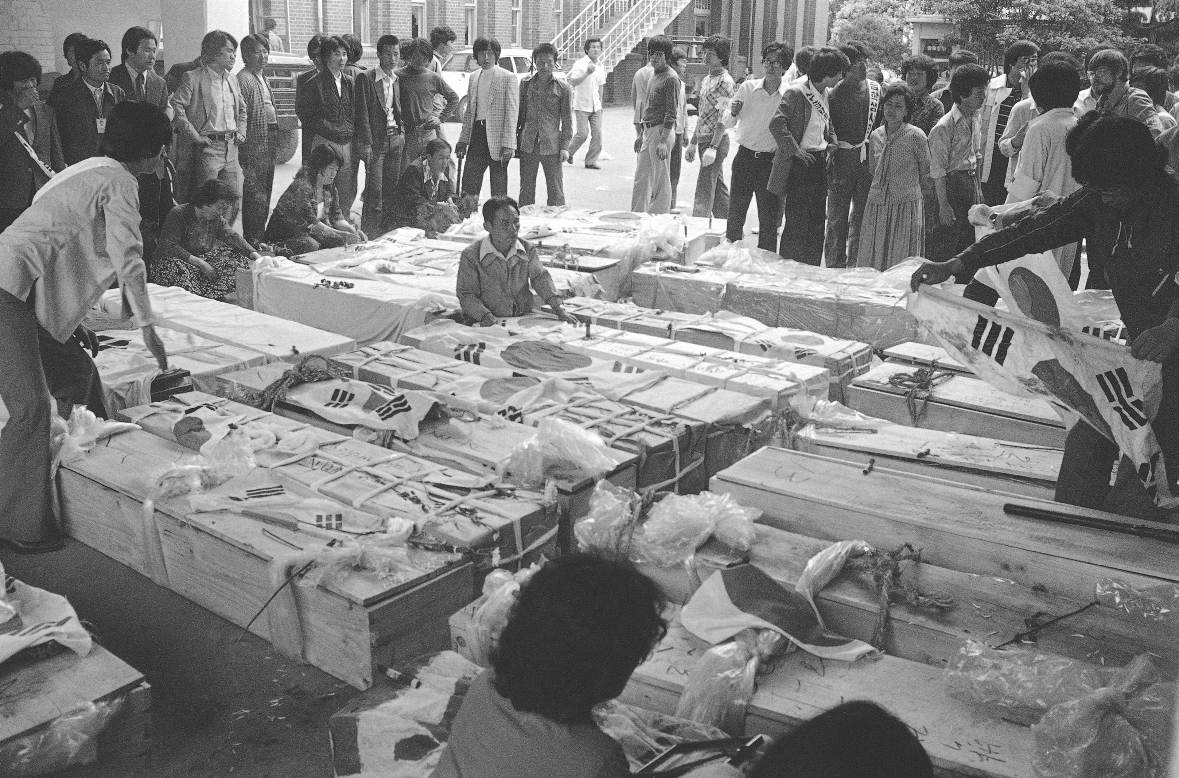 FILE- Families and relatives gather around the coffins of dead protesters at provincial headquarters in Gwangju (Kwangju), South Korea, May 23, 1980, some 250 kilometers south of Seoul, South Korea. (AP Photo/Kin Chon Kil, File)