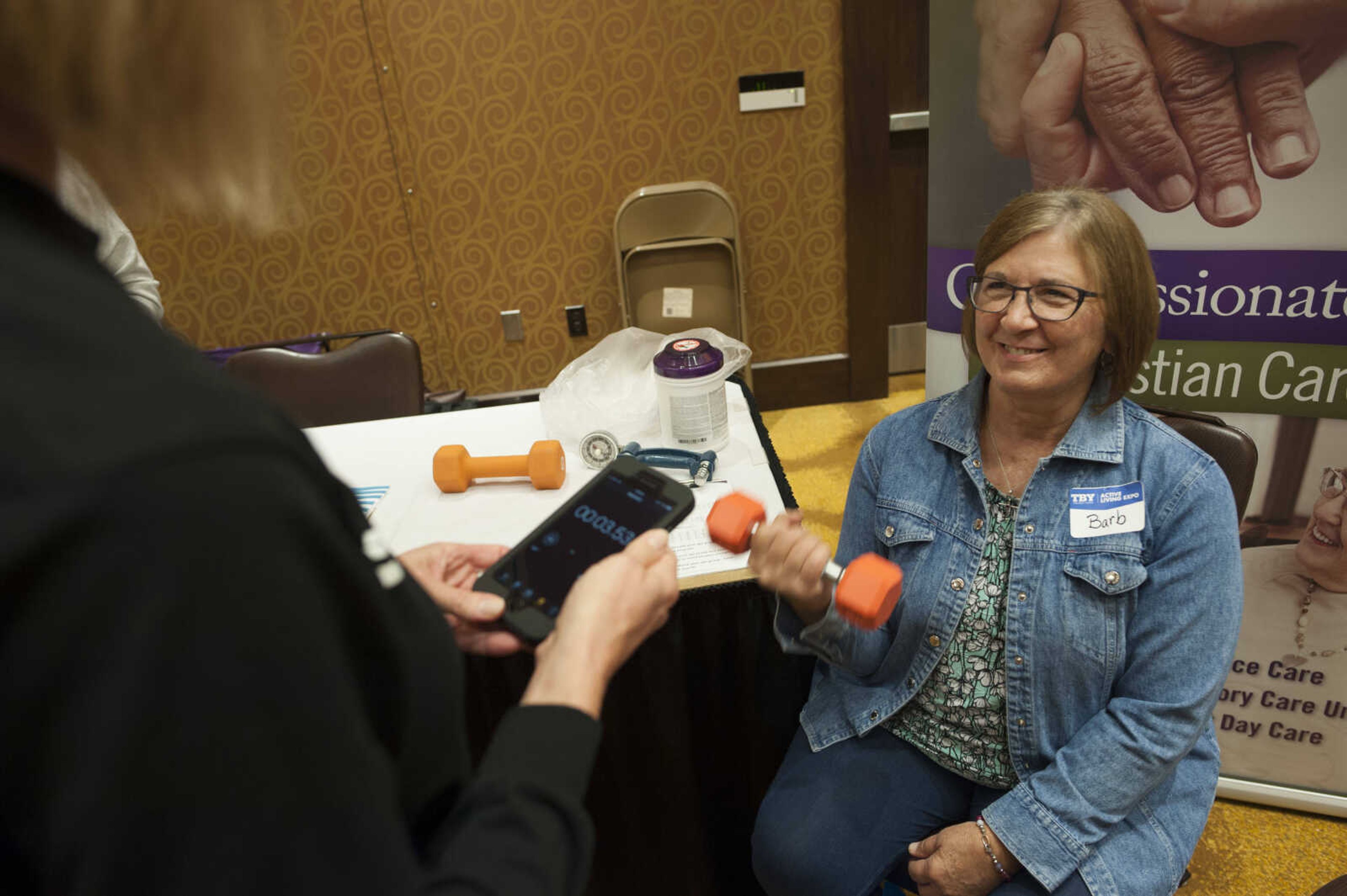 Barb Morgan, right, performs a series of bicep curls while Christi Schlimpert of the Lutheran Home, left, times her during the TBY Active Living Expo Wednesday, Oct. 9, 2019, at the Isle Casino in Cape Girardeau.