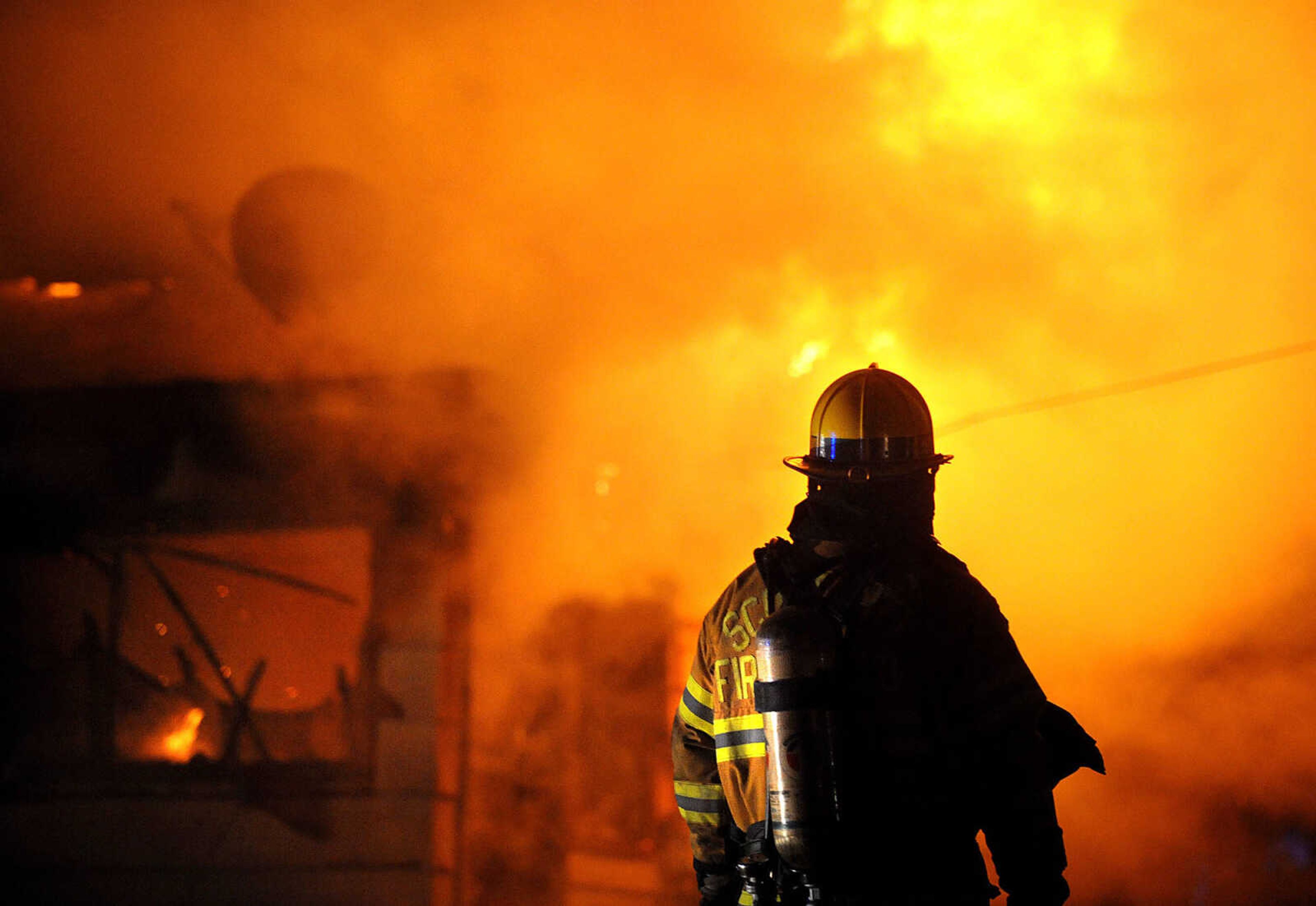 LAURA SIMON ~ lsimon@semissourian.com

Wes Drury, safety officer with the Scott City fire department, stands outside a house fire at 308 W. Missouri Blvd. in Scott City, Wednesday, Dec. 18, 2013, while members of the Scott City Fire Department battle the blaze with mutual aide from the Cape Girardeau Fire Department.