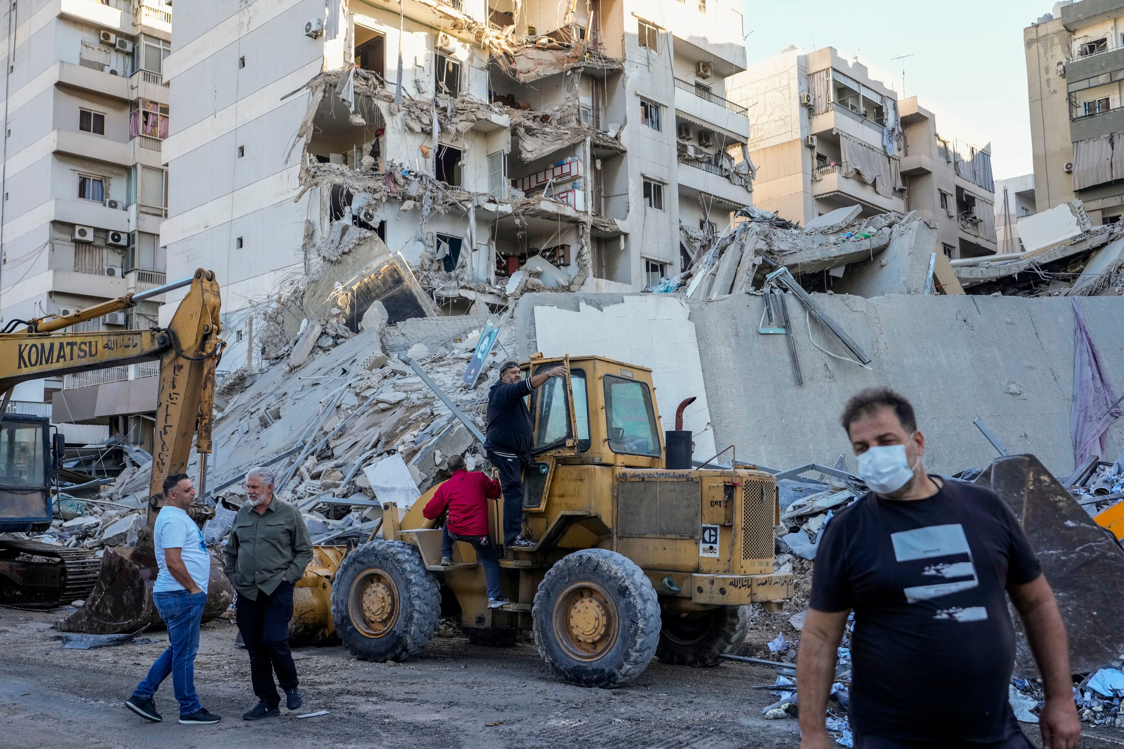 Rescue workers use a bulldozer to remove rubble of destroyed buildings at the site of an Israeli airstrike on Sunday night that hit several branches of the Hezbollah-run al-Qard al-Hassan in Beirut's southern suburb, Lebanon, Monday, Oct. 21, 2024. (AP Photo/Hassan Ammar)