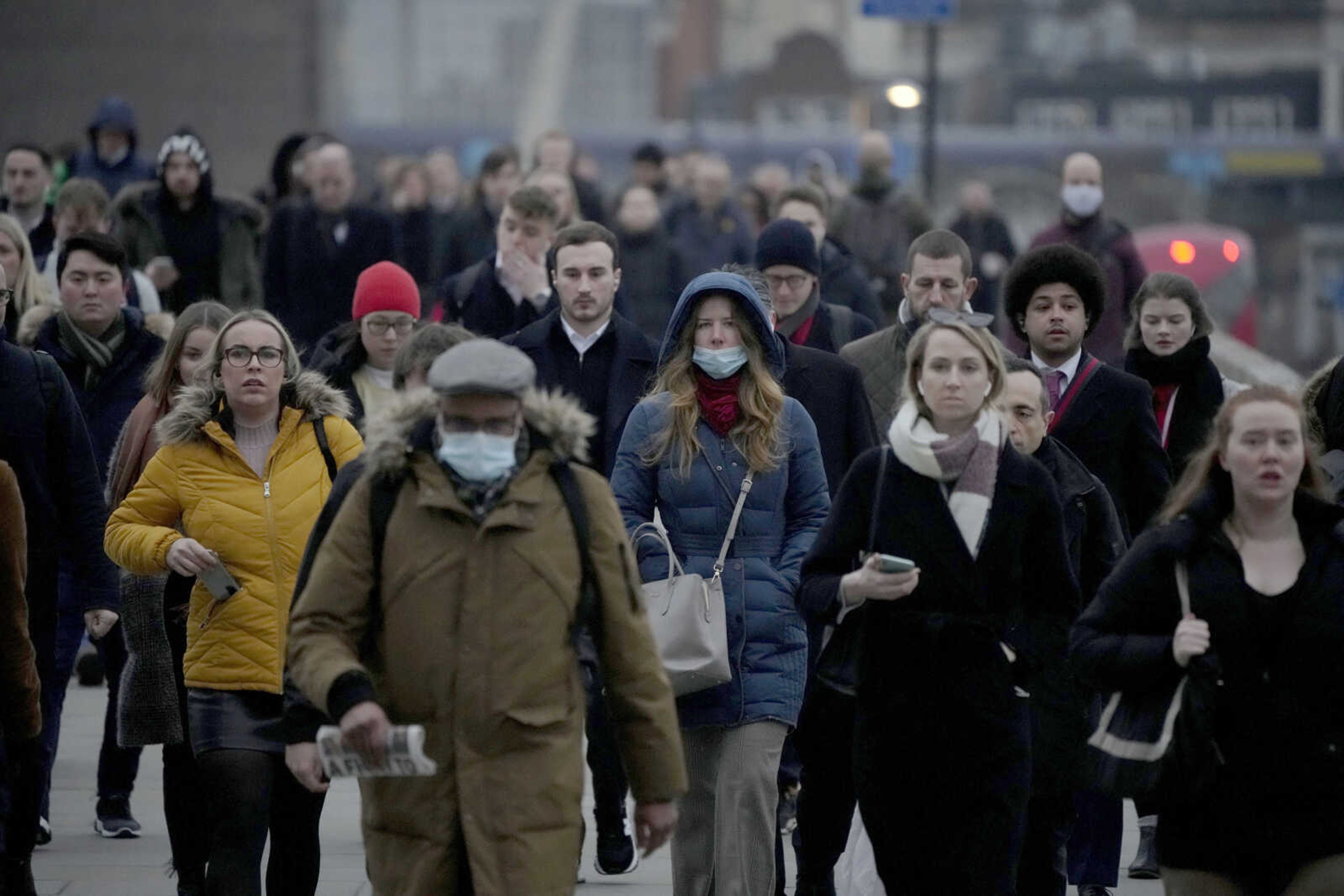 Workers walk over London Bridge toward the City of London financial district during the morning rush hour Jan. 24 in London.