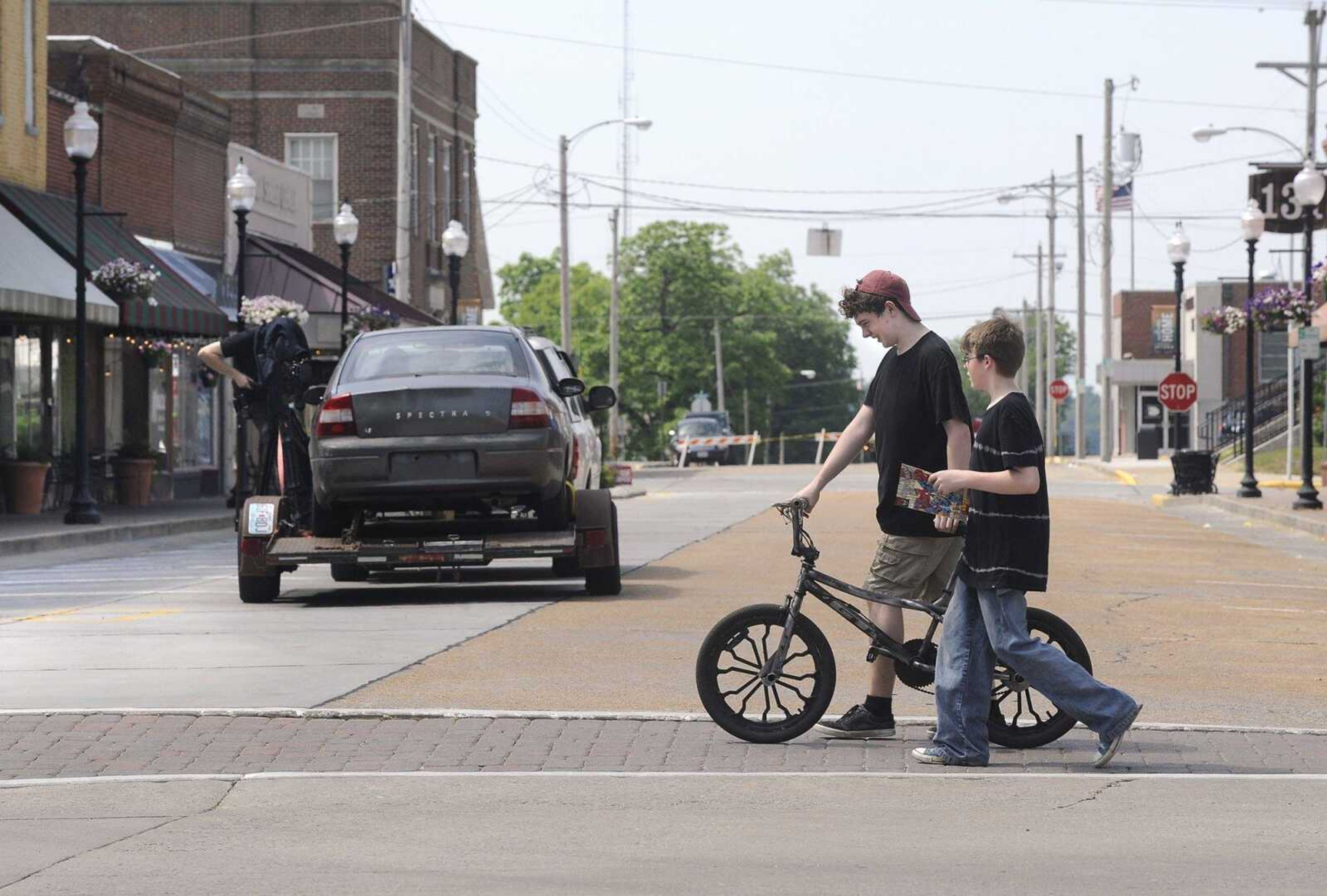 Cody Griggs walks his bicycle with Layton Lipke, both of Jackson, across High Street after cinematographer PJ Gaynard rolls past them with a camera-car shooting a scene for the movie "All Nite Skate" on Friday in uptown Jackson.