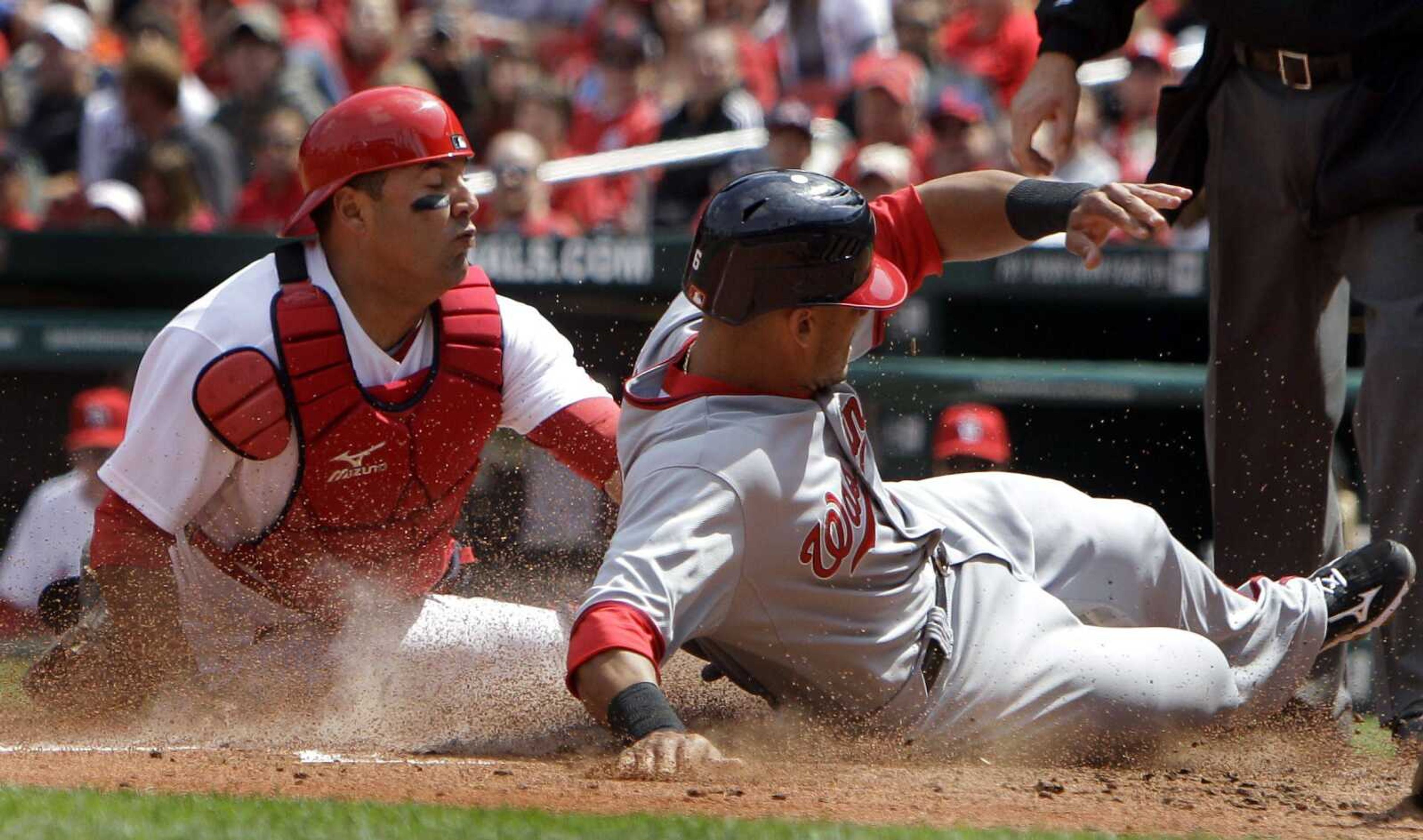 Washington Nationals' Ian Desmond, right, avoids the tag from St. Louis Cardinals catcher Gerald Laird to score by stealing home during the third inning in the first game of a doubleheader baseball game Wednesday, April 20, 2011, in St. Louis. Desmond was able to steal home when teammate Laynce Nix stole second. (AP Photo/Jeff Roberson)