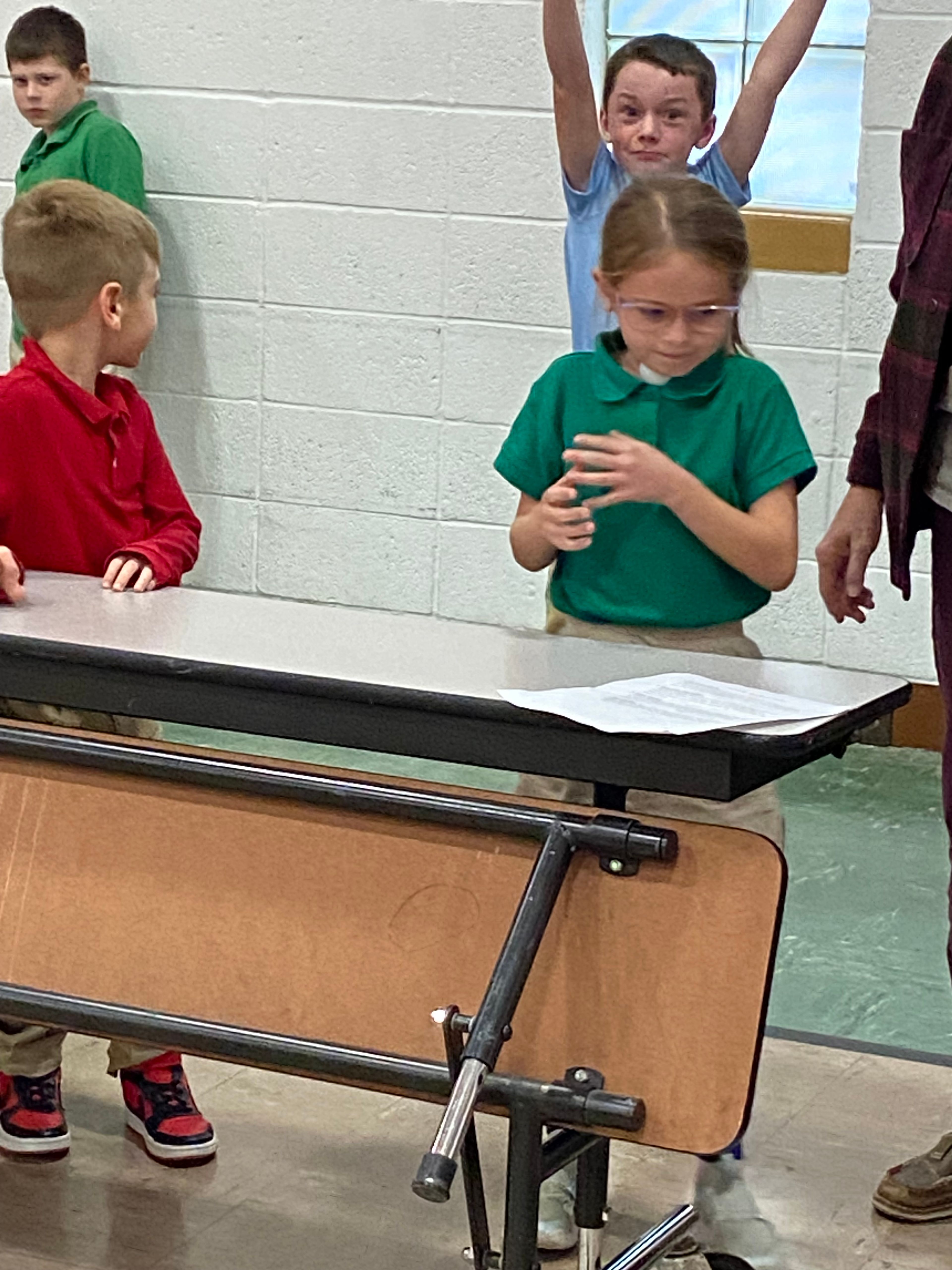 Berkley Dennis of St. Michael's house gets a ping pong ball in position in preparation to run it to the cup to drop it in.  Paxton Urhahn, Jameson Levan and Lane Seyer cheer her on to success.
