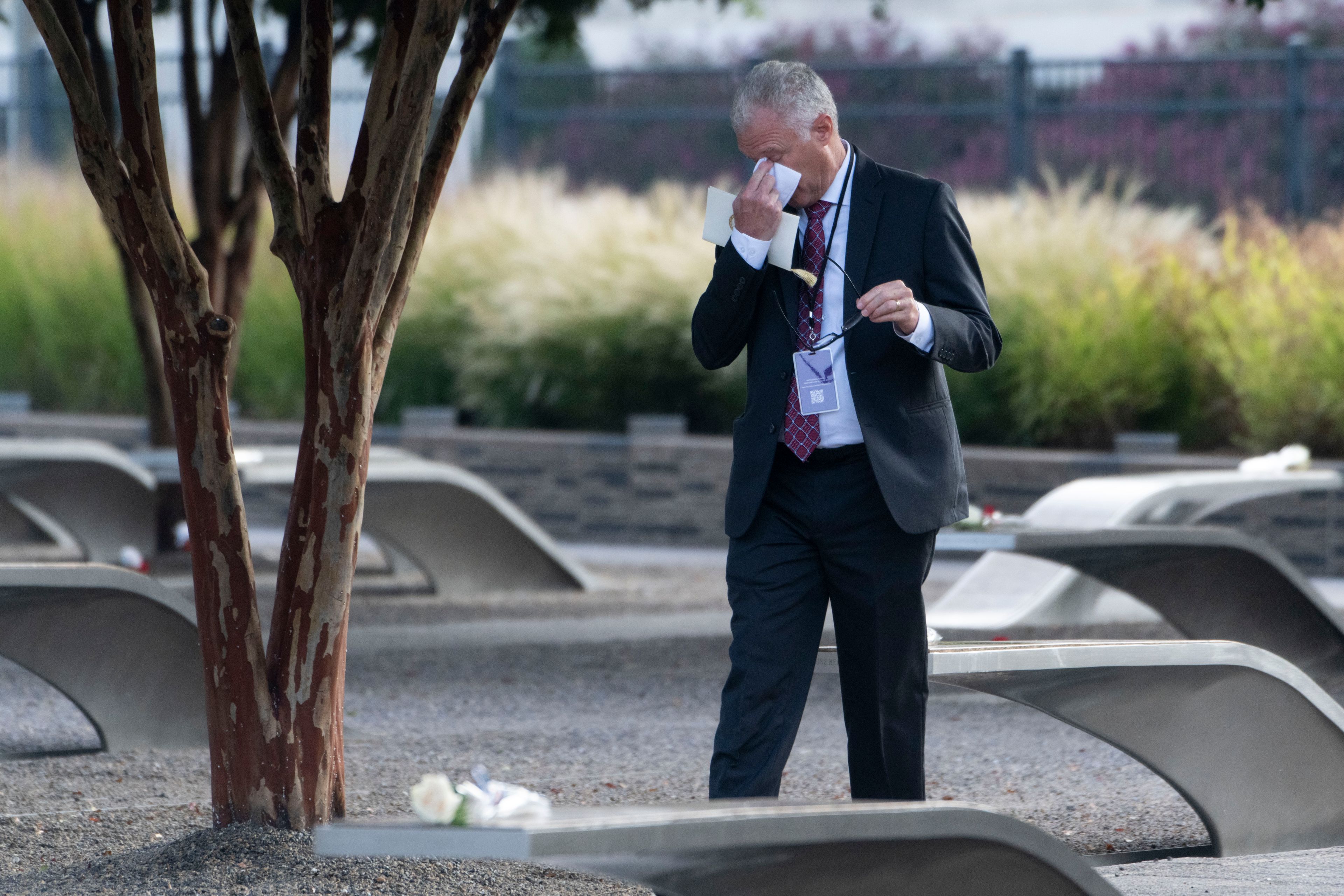 A man wipes his eyes as he walks through the 9/11 Pentagon Memorial on Wednesday, Sept. 11, 2024 in Washington. (AP Photo/Kevin Wolf)