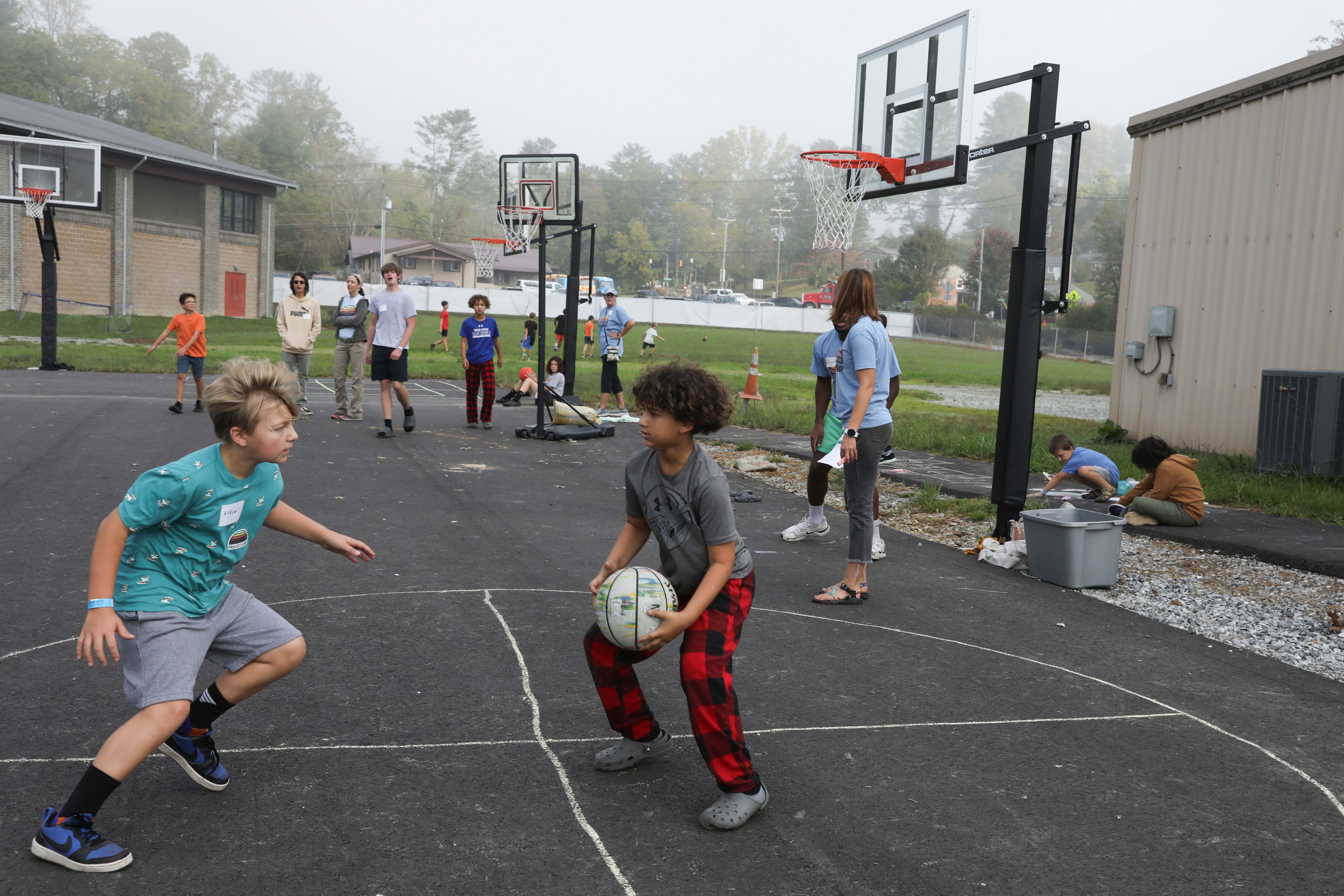 Boys play basketball at the Project:Camp pop-up daycamp for families impacted by Hurricane Helene in Brevard, N.C., Monday, Oct. 7, 2024. (AP Photo/Gabriela Aoun Angueira)