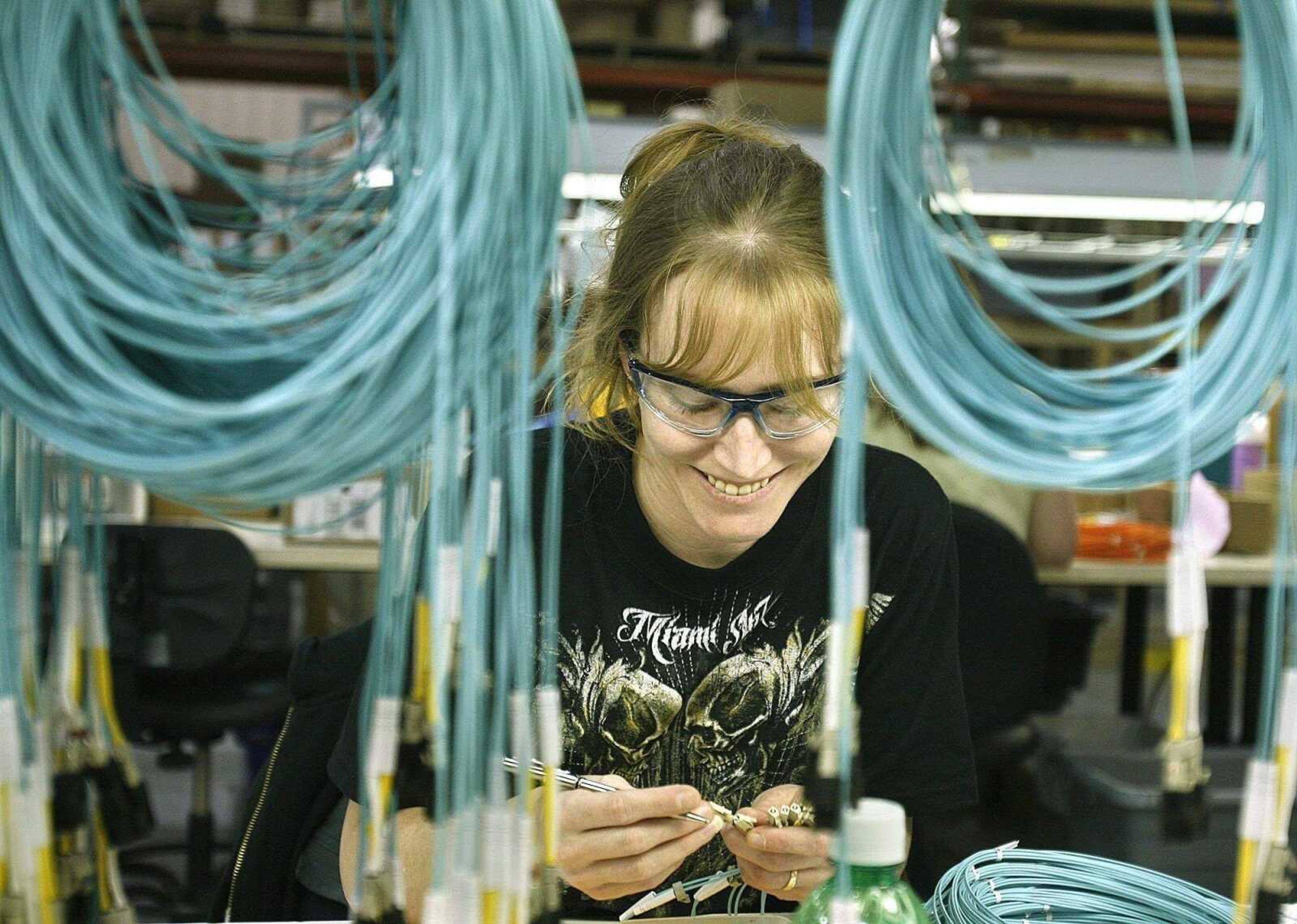 ELIZABETH DODD ~ edoddsemissourian.comChristy Huffman, a fiber technician, cuts and sands a fiber optic cable at Major Custom Cable in Fruitland. Major Custom Cable makes five to seven thousand cables per day.