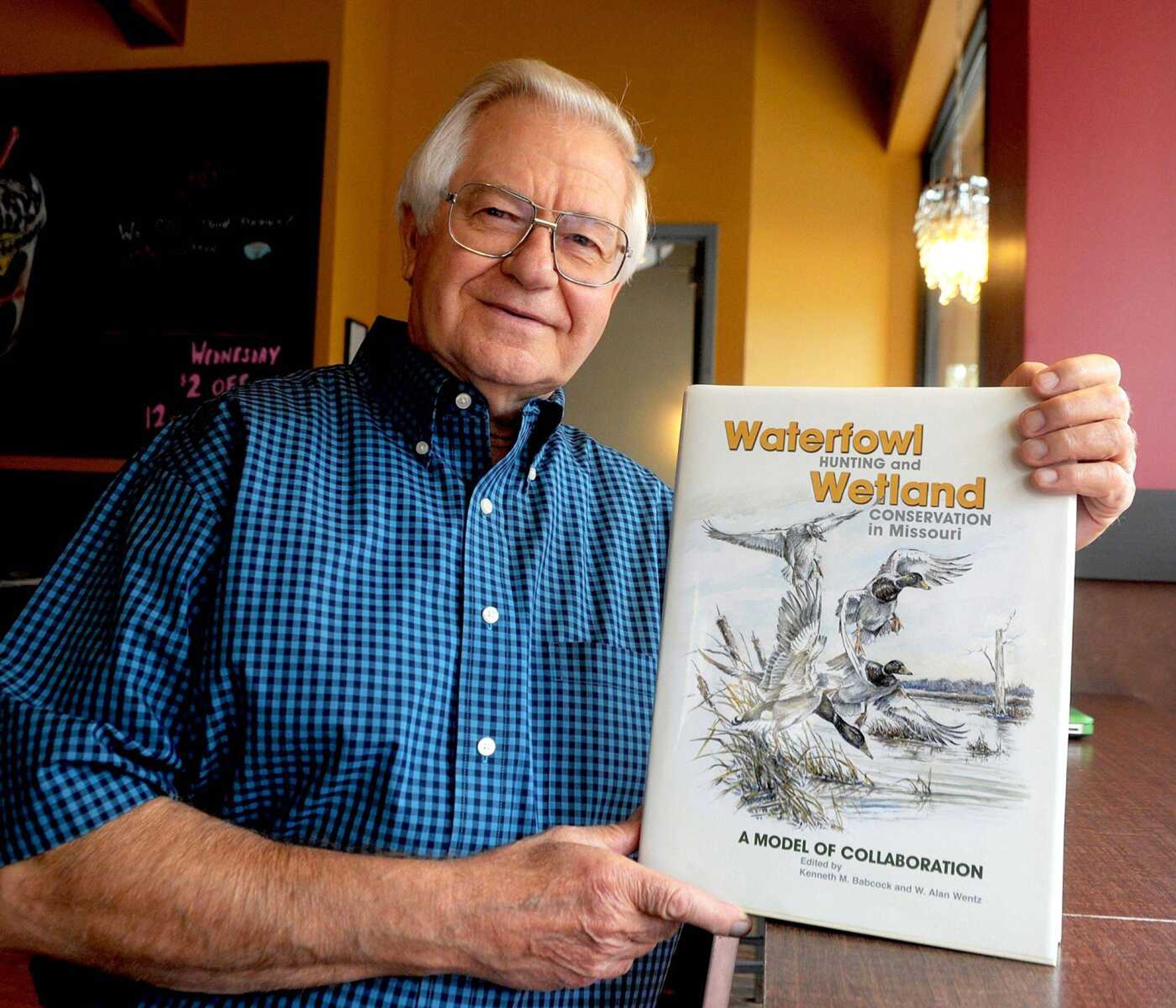 In this photo taken Oct. 2, wildlife photographer Glenn Chambers holds a copy of a book he co-authored called &#8220;Waterfowl Hunting and Wetland Conservation in Missouri&#8221; in Columbia, Missouri. The Boy Scouts of America recently gave Chambers its 40th William T. Hornaday Gold Medal, a lifetime achievement award for environmental conservation. Chambers is the first Missourian to receive the honor. (Don Shrushell ~ The Columbia Daily Tribune)