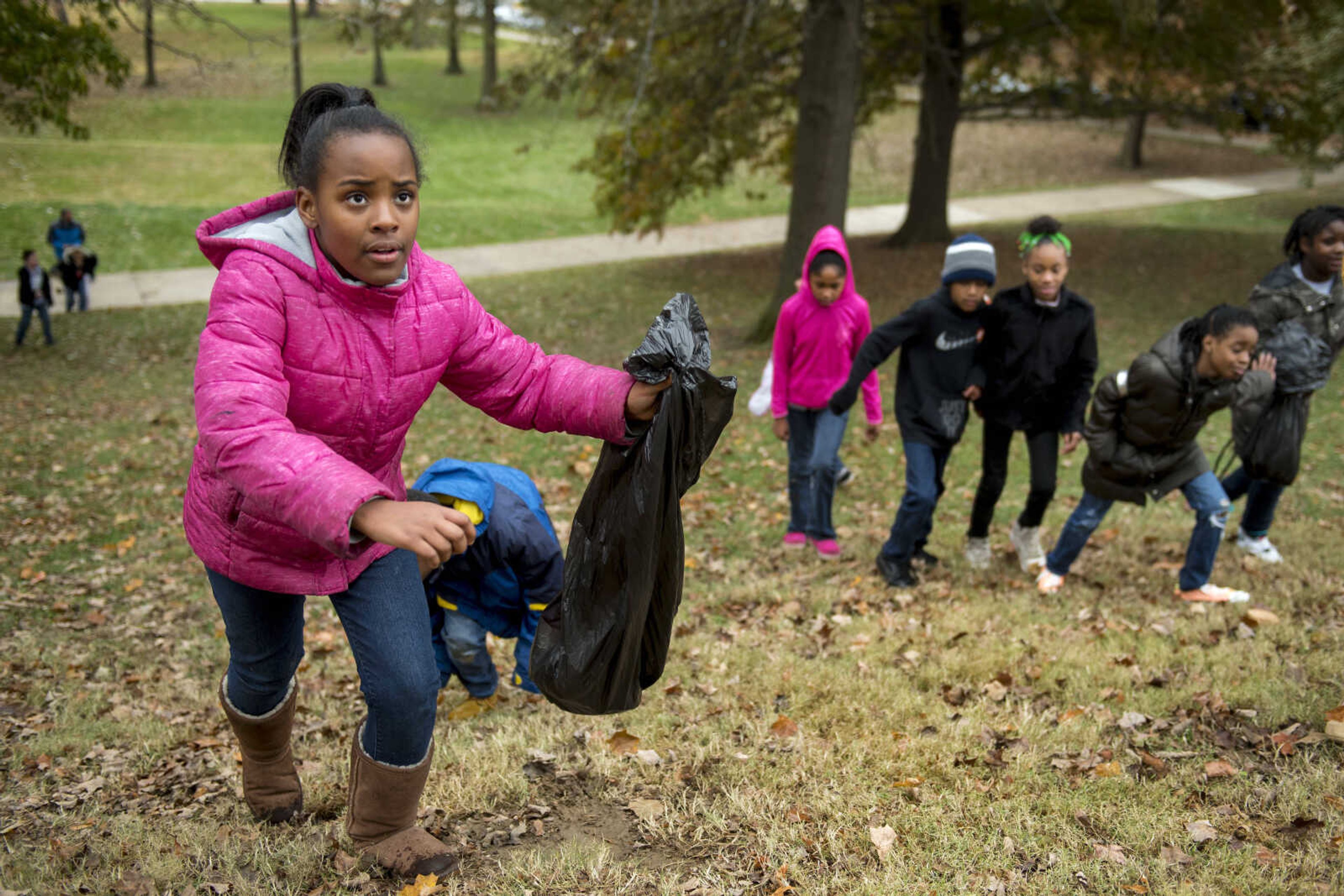 Aryssa Bobo, 9, climbs up a hill on the Southeast Missouri State University campus with a trash bag while participating in a beautification project for Jefferson Elementary students Monday.